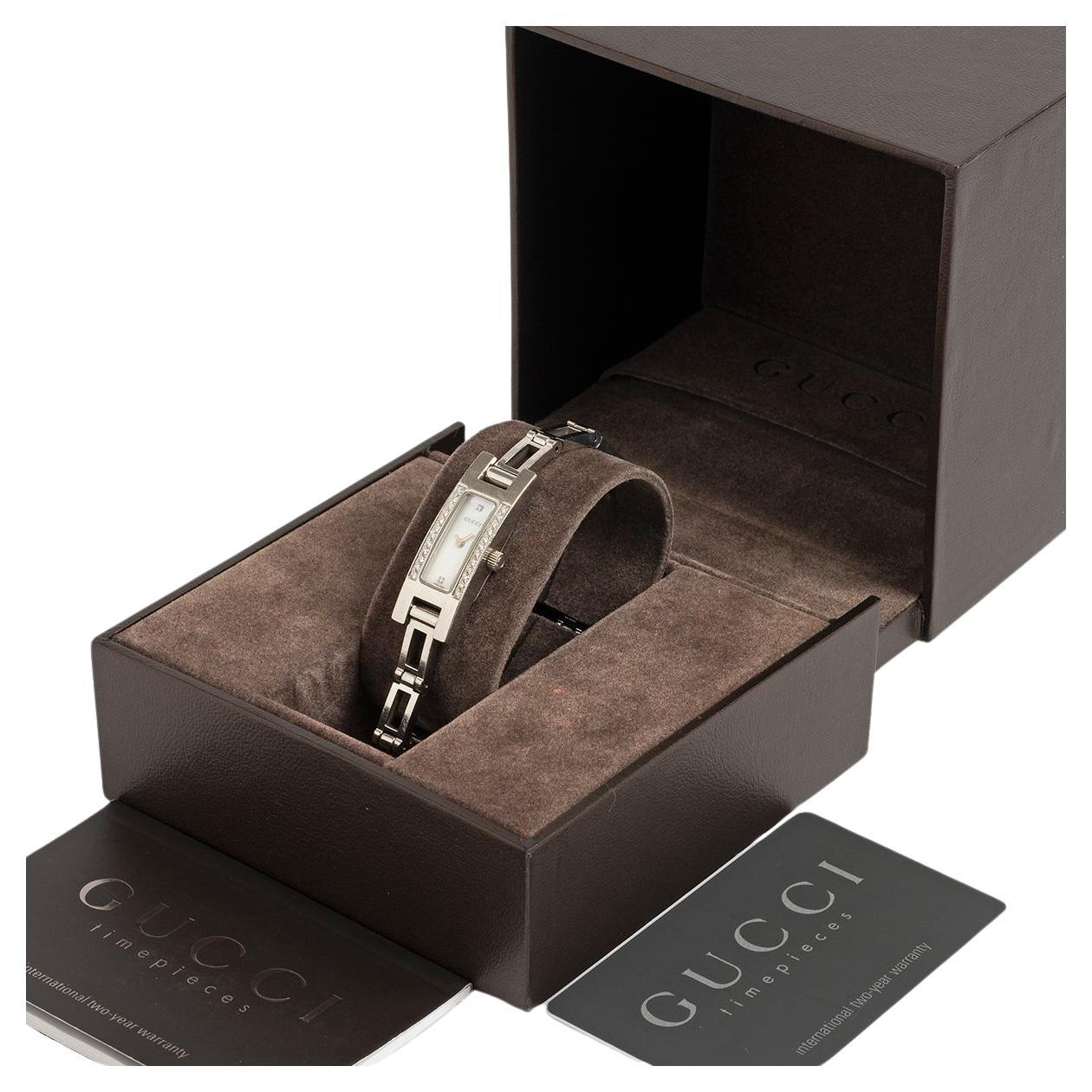 Notre belle référence néo vintage Gucci 3900L présente un boîtier en acier inoxydable de 14 mm par 32 mm avec un bracelet échelle en acier inoxydable. Le boîtier est serti en usine de diamants et le cadran en nacre est orné de diamants à douze et