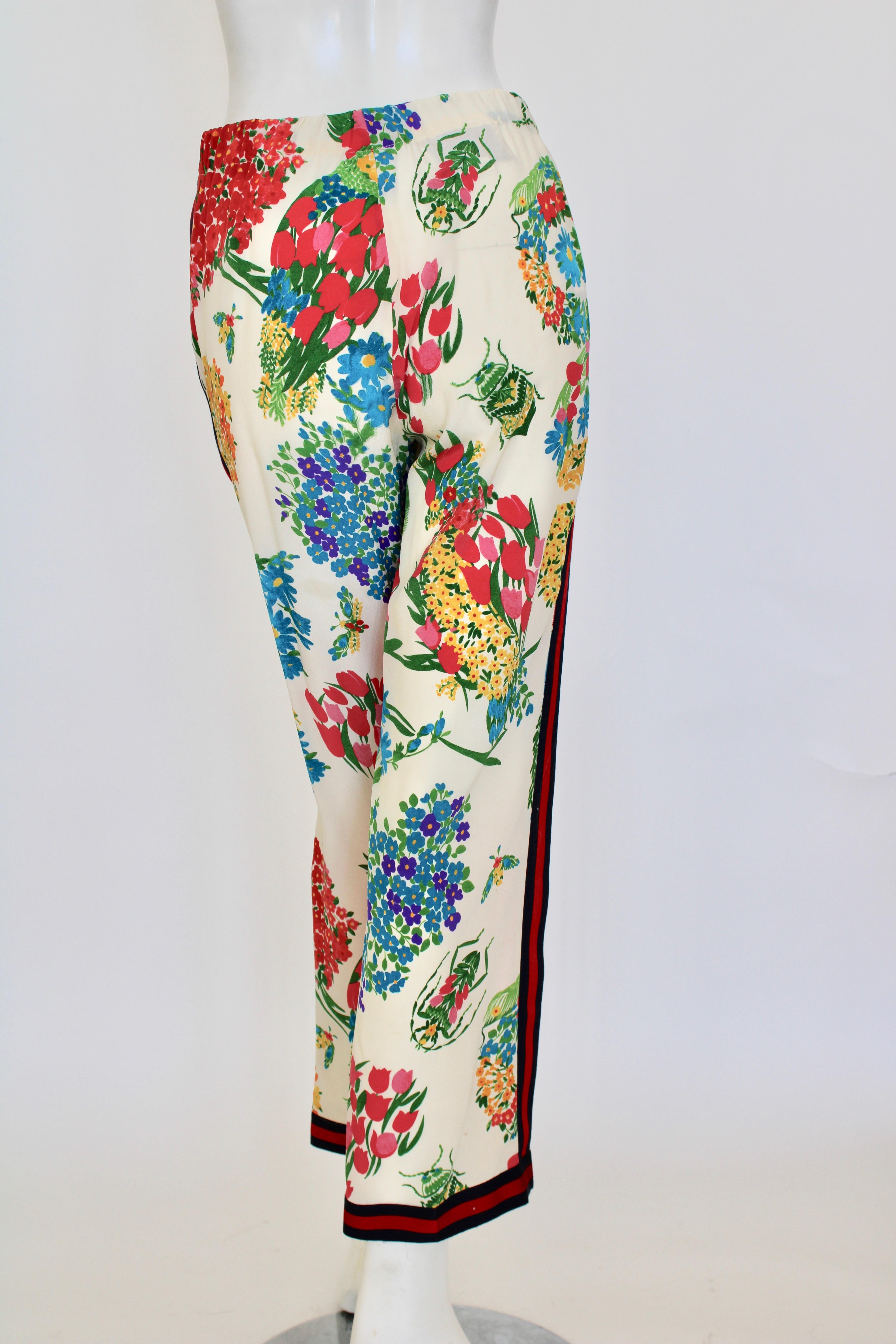 Ivory multi-colored printed silk pants with an elastic waist, button up functional buttons. Side stripe trim in red and navy along sides of pants and bottom cuff.