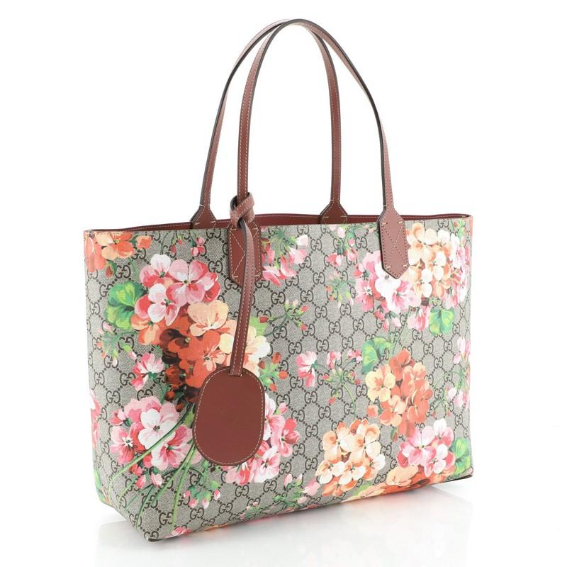 This Gucci Reversible Tote Blooms GG Print Leather Medium, crafted from blooms GG print leather, features tall leather handles and subtle Gucci logo. Its wide top opens to a reversible purple leather interior. 

Estimated Retail Price: