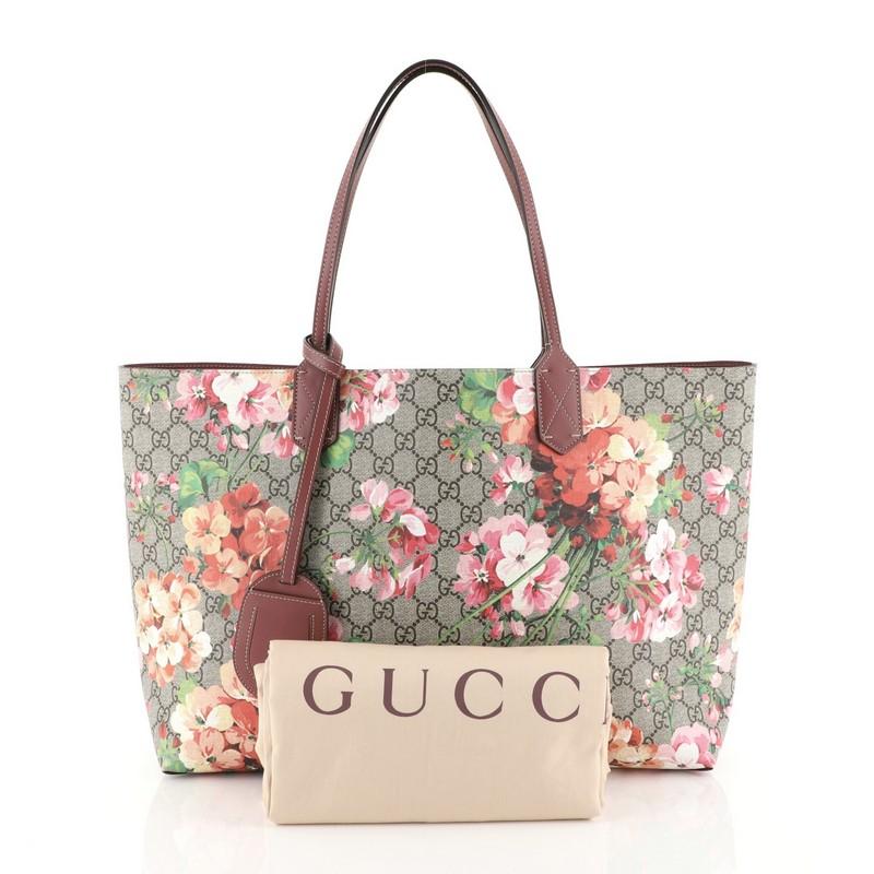 This Gucci Reversible Tote Blooms GG Print Leather Medium, crafted from brown blooms GG print leather, features tall slim handles and subtle Gucci logo. Its wide top opens to a reversible pink leather interior. These are professional pictures of the