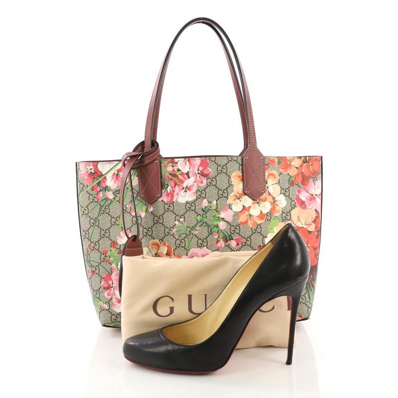 This Gucci Reversible Tote Blooms GG Print Leather Small, crafted from brown GG blooms print leather, features tall slim handles and subtle Gucci logo. Its wide top opens to a reversible mauve leather interior. **Note: Shoe photographed is used as a