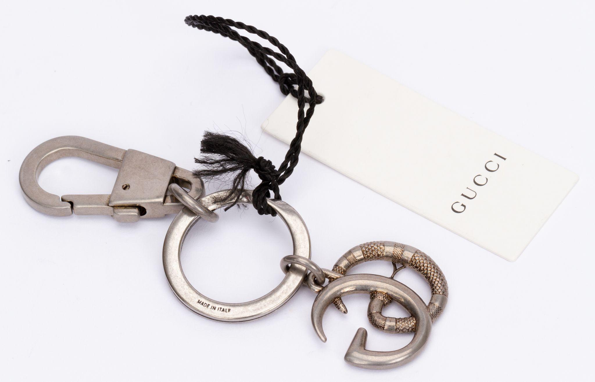 Gucci silver key ring with a GG logo charm. The piece comes with the ring and a clasp. It is brand new and includes the tag, original box and dust cover.
