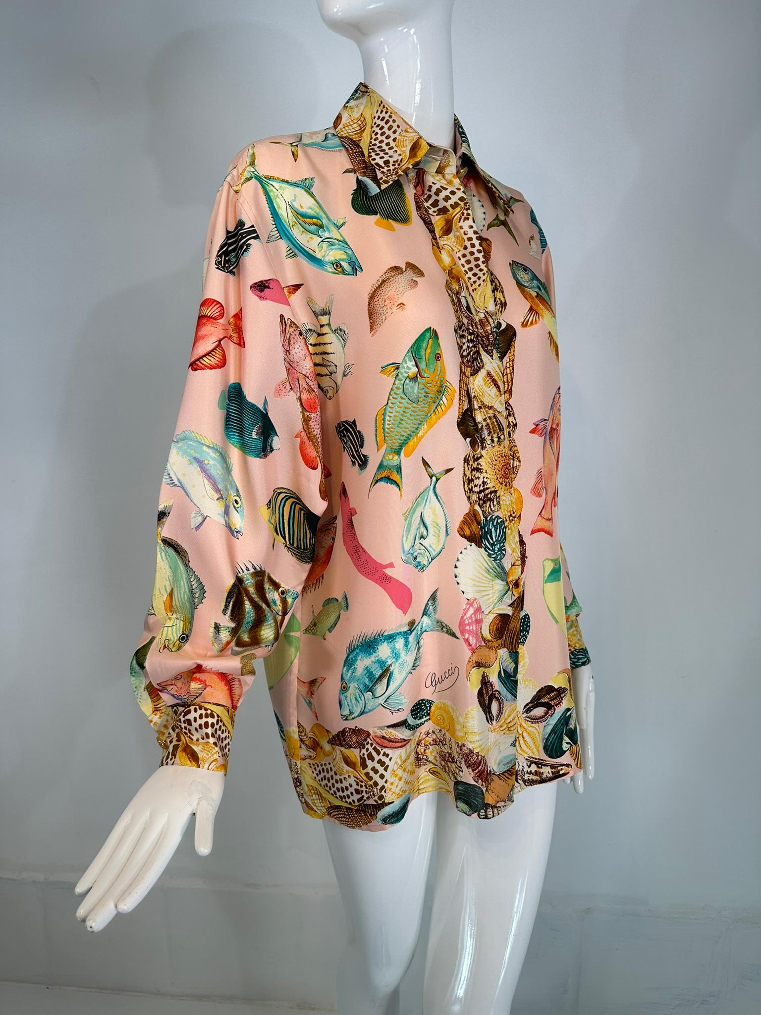 Gucci S/S 1992 runway pink silk twill fish & sea shells print, oversize shirt/tunic 42.  Rare to find, from 1992. Schools of fish scattered across a pale pink ground, the borders and facings are done in collections of sea shells.
Big shirts were the