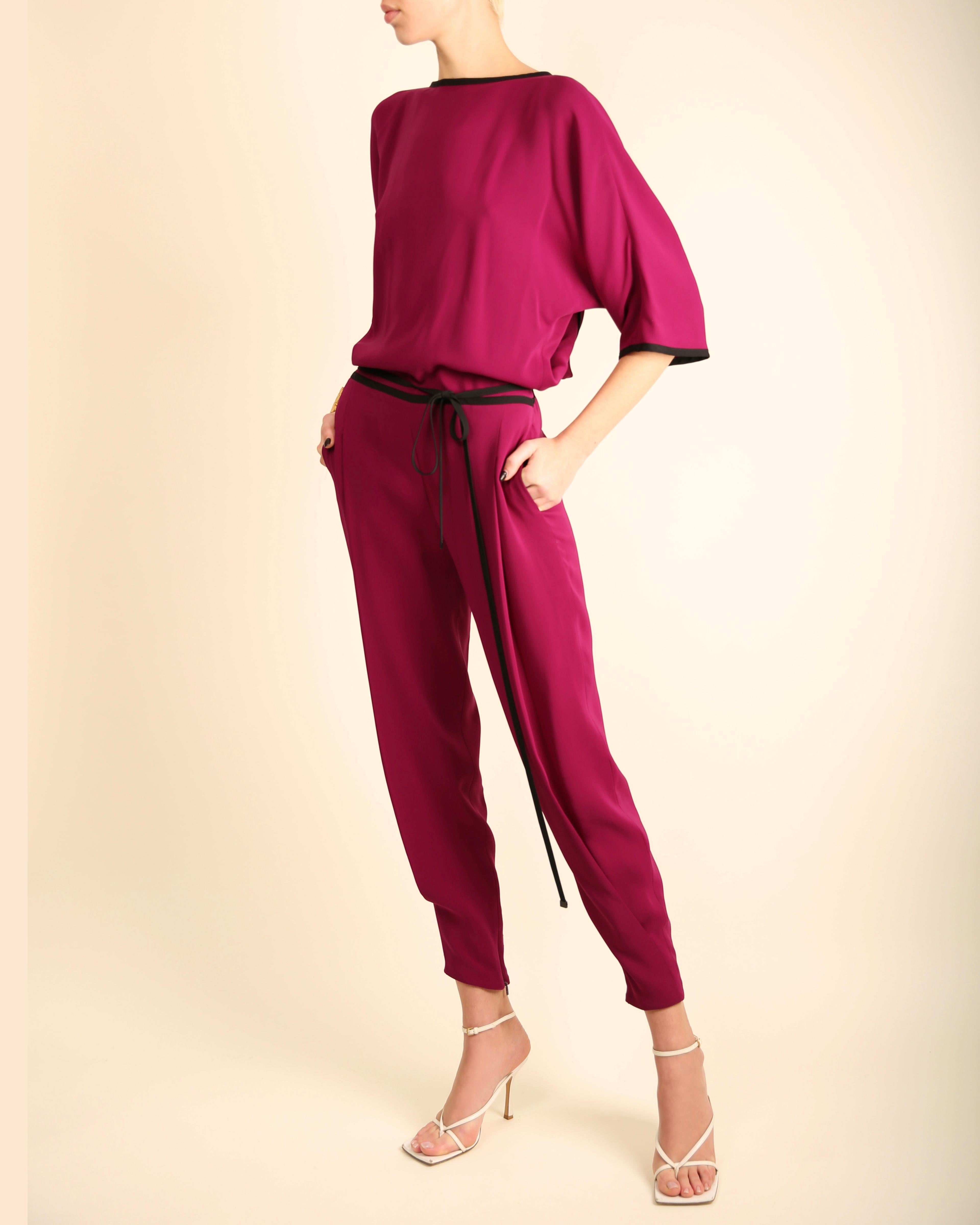 LOVE LALI Vintage

Gucci S/S 2014 jumpsuit in magenta with black trim
Dolman style sleeves
Tapered leg with ankle zips
Ties at the waist with long black ties
Pockets
Cross over low back
Concealed back zip

Composition:
100% Silk

Size:
IT