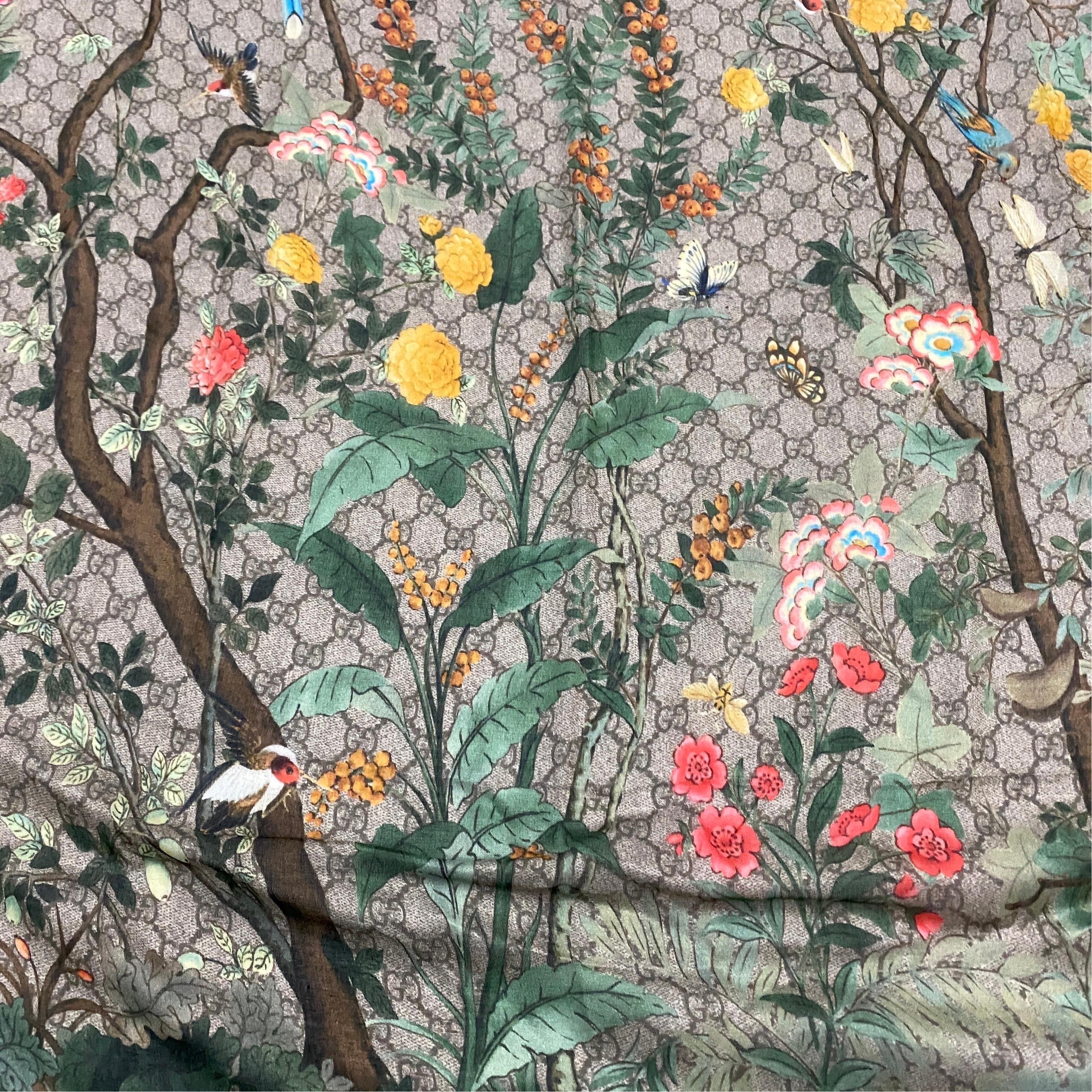 A scarf in wool and silk with flora and fauna illustration designed and manufactured in Italy By Gucci. The Scarf is a beautiful and timeless piece of fashion that showcases the design and craftsmanship of the iconic Italian fashion house. Gucci is