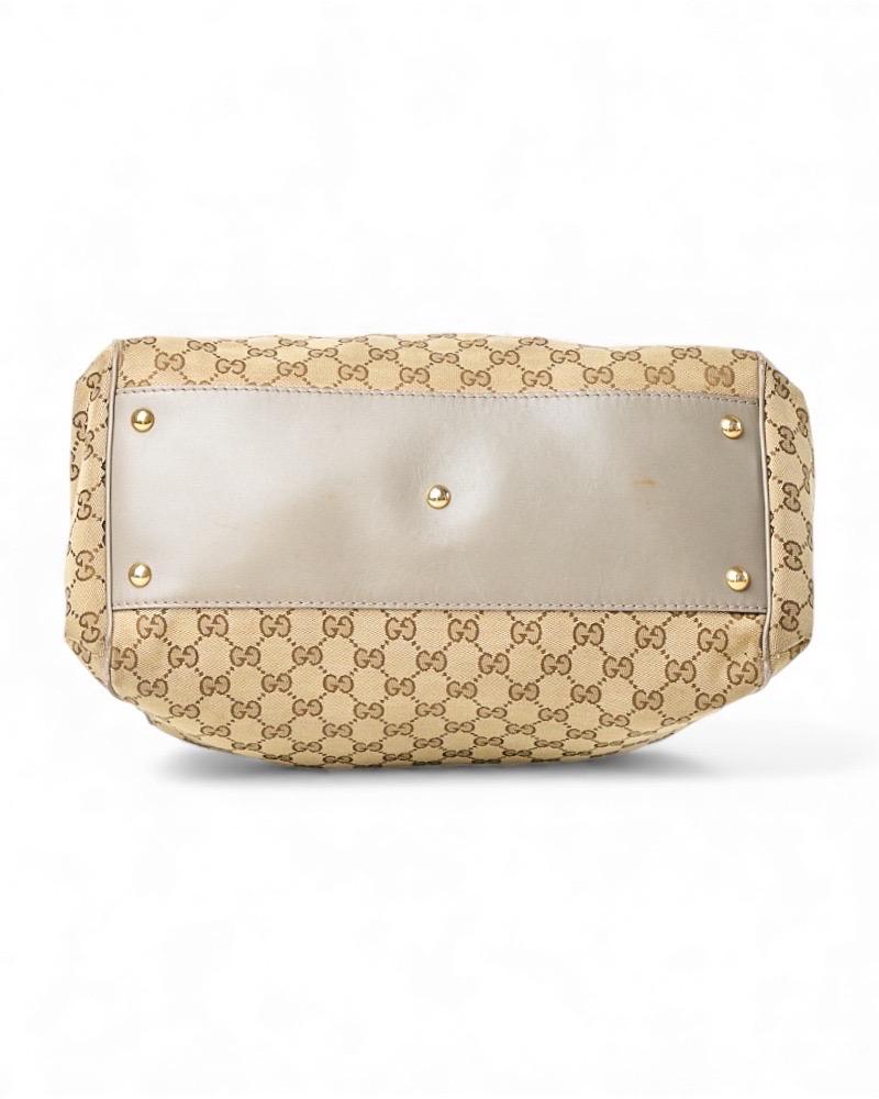 Borsa firmata Gucci, linea Scarlett, modello shopper nella misura medium, realizzata in tela nella fantasia classica GG Supreme con inserti in pelle nella colorazione fango e hardware dorato. Dotée d'une tête supérieure avec deux curseurs, réalisée