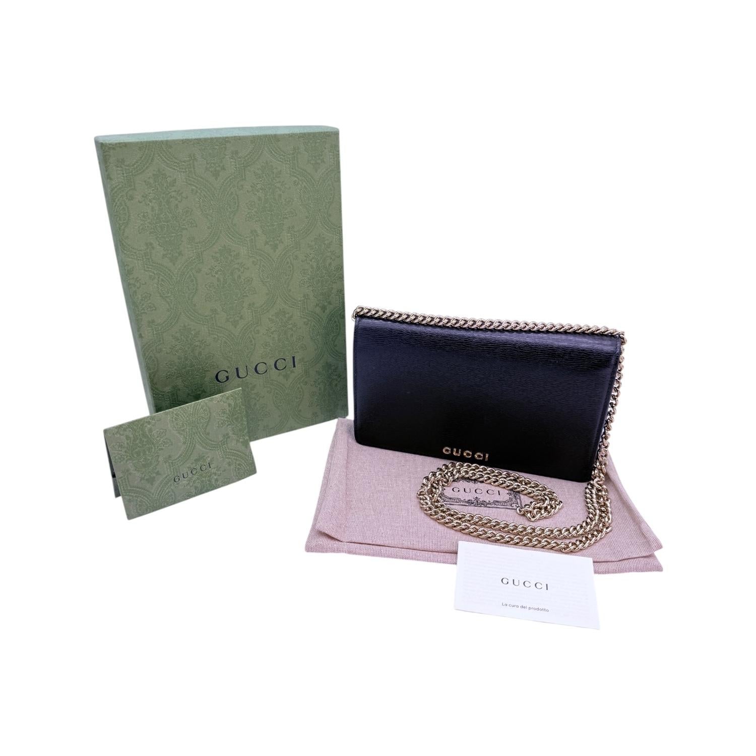Experience luxury and style with the Gucci Script Black Wallet on Chain. Crafted with premium leather and made in Italy, this versatile piece features a snap button closure and interior pockets for organization. The gold-tone hardware adds a touch