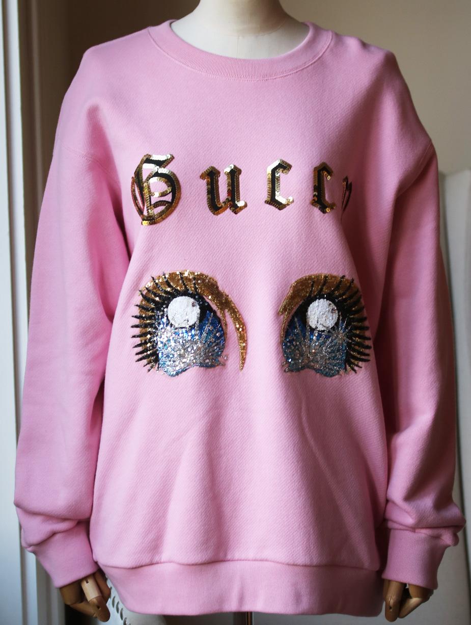 An oversize sweatshirt with embroidered manga eyes from 'viva! Volleyball' and gothic guccy print with sequin trim on the front and gothic 