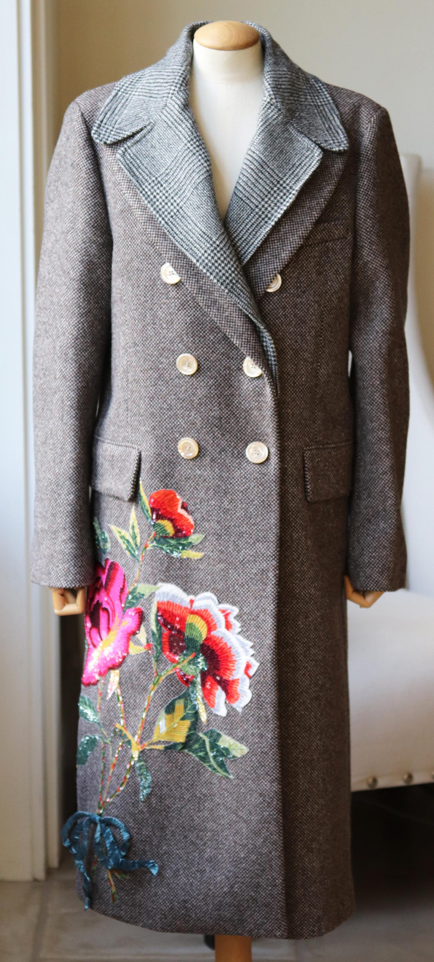 Dieser Mantel von Gucci ist ein wahres Beispiel für die außergewöhnliche Handwerkskunst des Labels mit seinen verspielten, mit Pailletten verzierten Zierblumen auf der einen Seite und einem abnehmbaren, doppellagigen Revers an der  ausschnitt..
Er