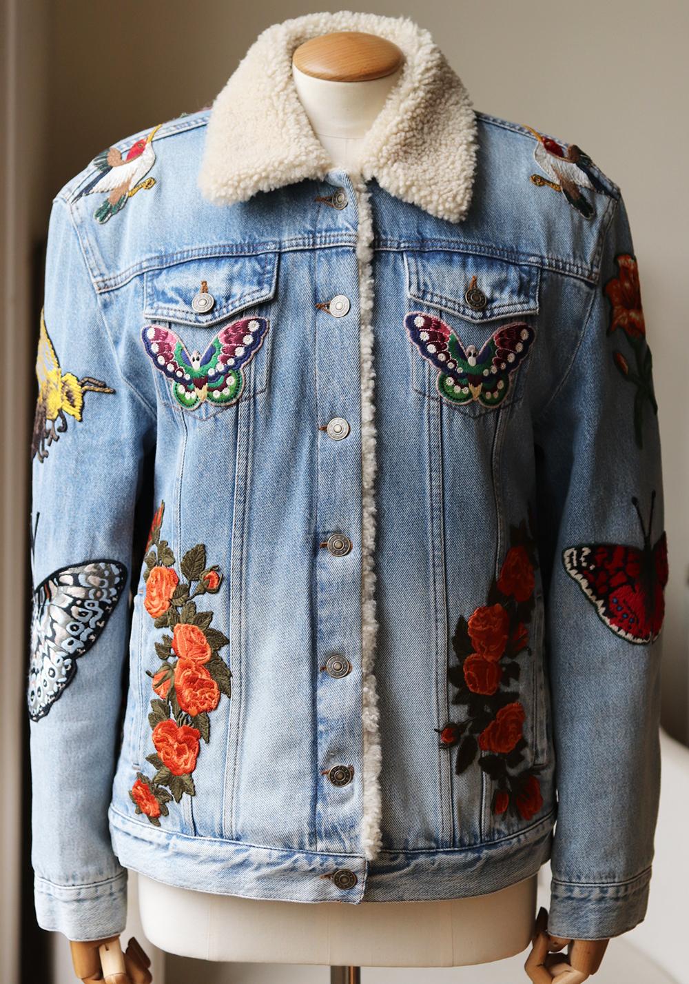 Questa giacca Gucci è un vero esempio dell'eccezionale maestria del marchio con i suoi fiori ricamati, le farfalle e la testa di tigre.
Realizzato in Italia con un denim azzurro sbiadito in una silhouette squadrata, è foderato e rifinito con un