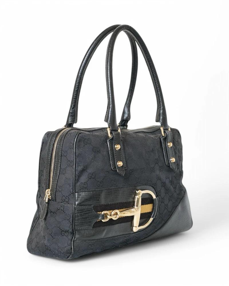 Gucci signature bag, Horsebit line, Shopper model, made of black canvas with leather trim and gold hardware. Featuring a semi-circular closure with a double slider, internally lined in tone-on-tone canvas with convenient pocket, the bag is quite