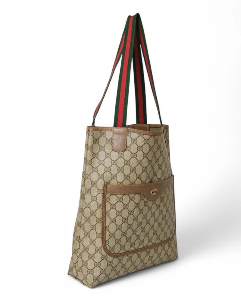 Bag  signed Gucci, Shopper Vertical model, made of canvas with the classic GG Supreme pattern, finished with leather details and gold hardware. This bag has no closure, offering a practical and versatile design. The interior is lined in tone-on-tone