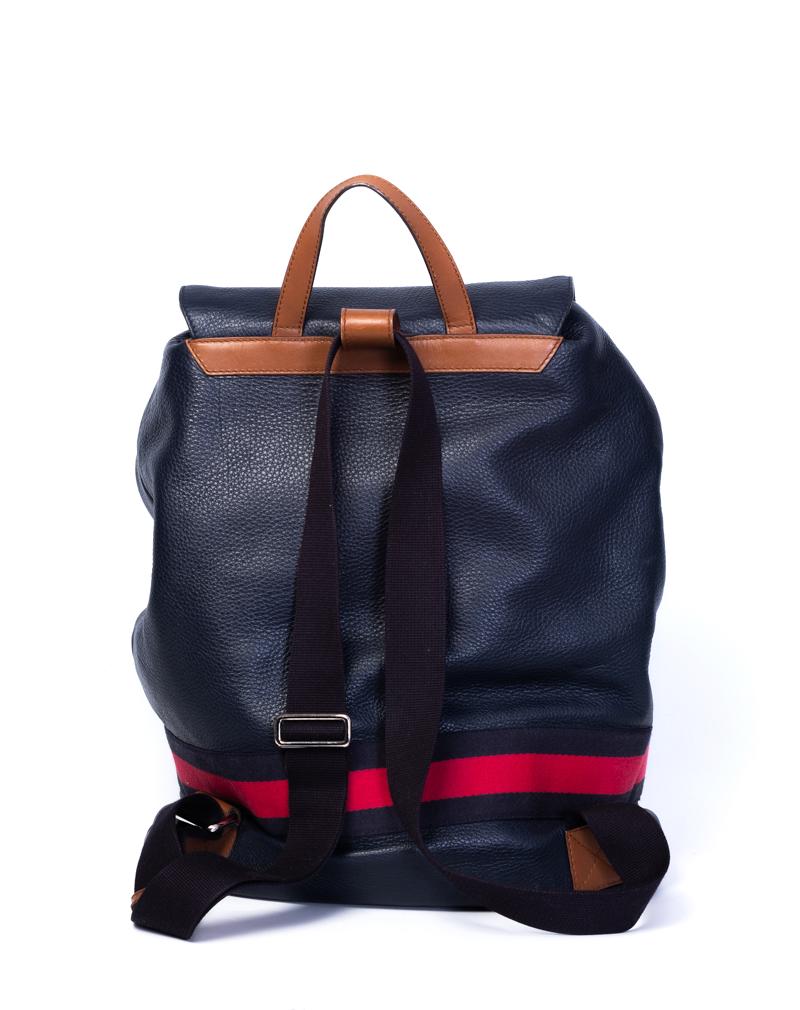 Lo zaino Gucci presenta un manico superiore in pelle marrone, spallacci in nylon regolabili blu navy e finiture in argento. La patta e la chiusura a coulisse si aprono su un interno in tessuto intrecciato beige con cerniera e tasche