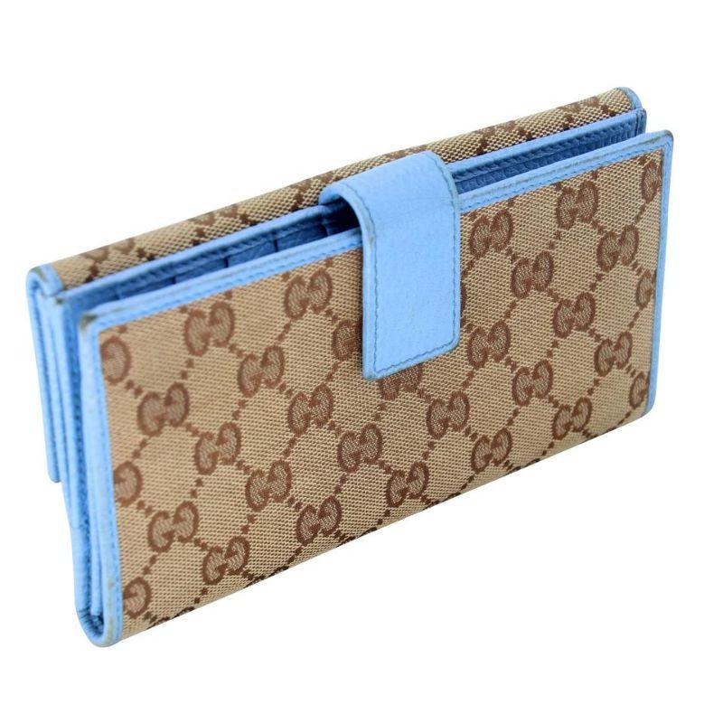 Gucci Signature Canvas Long Leather Trim GG Continental Wallet GG-0729n-0006

This stylish clutch wallet is finely crafted of baby blue leather on beige Gucci GG fabric with a frontal closure on the cross over strap. This unsnaps to a leather