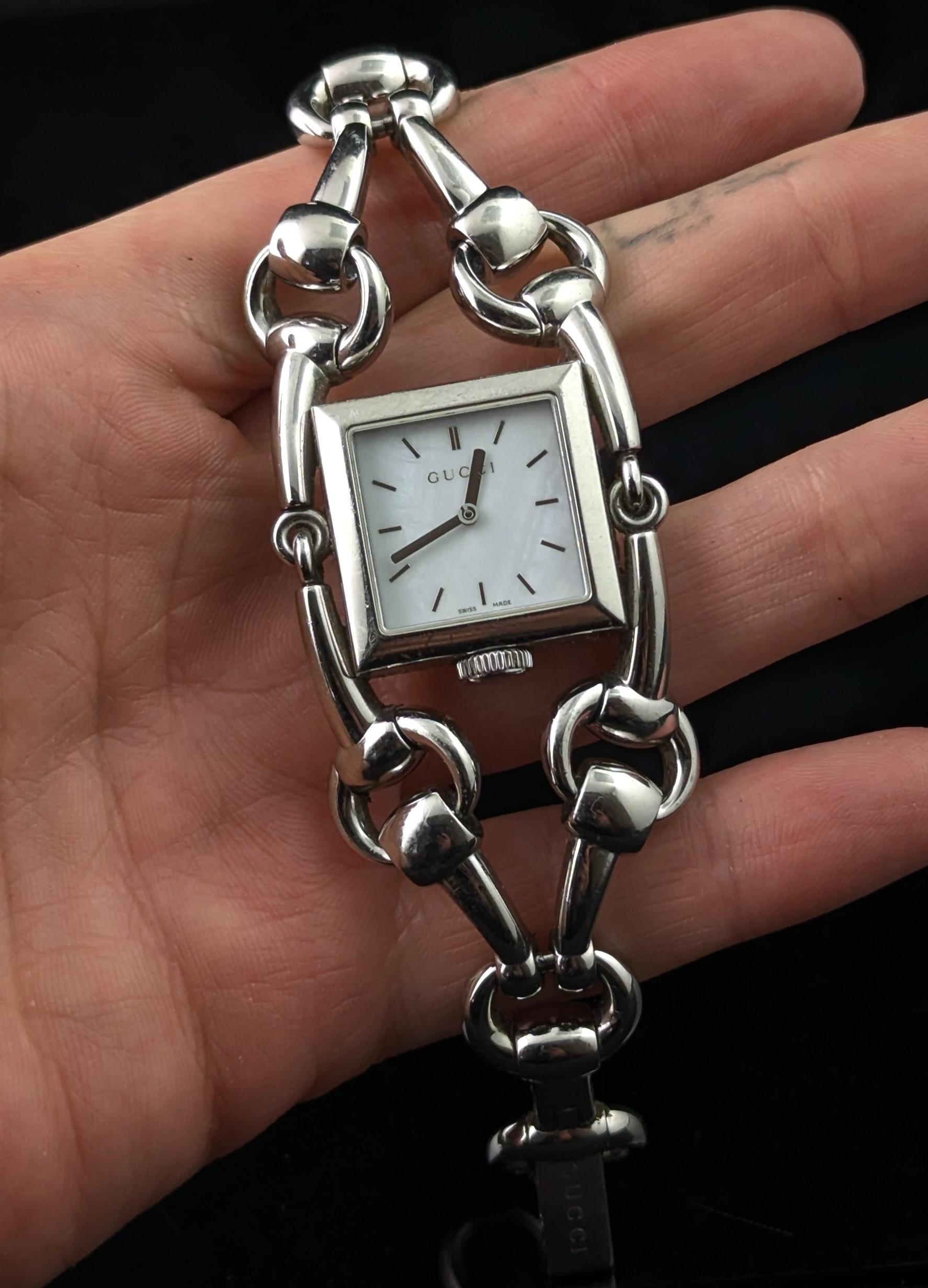 Un elegante e icónico reloj Gucci Signoria de acero inoxidable.

Se trata de un reloj de pulsera con una bonita y elegante correa de acero inoxidable con el característico diseño de bocado y el cierre de la marca Gucci.

La caja es de acero