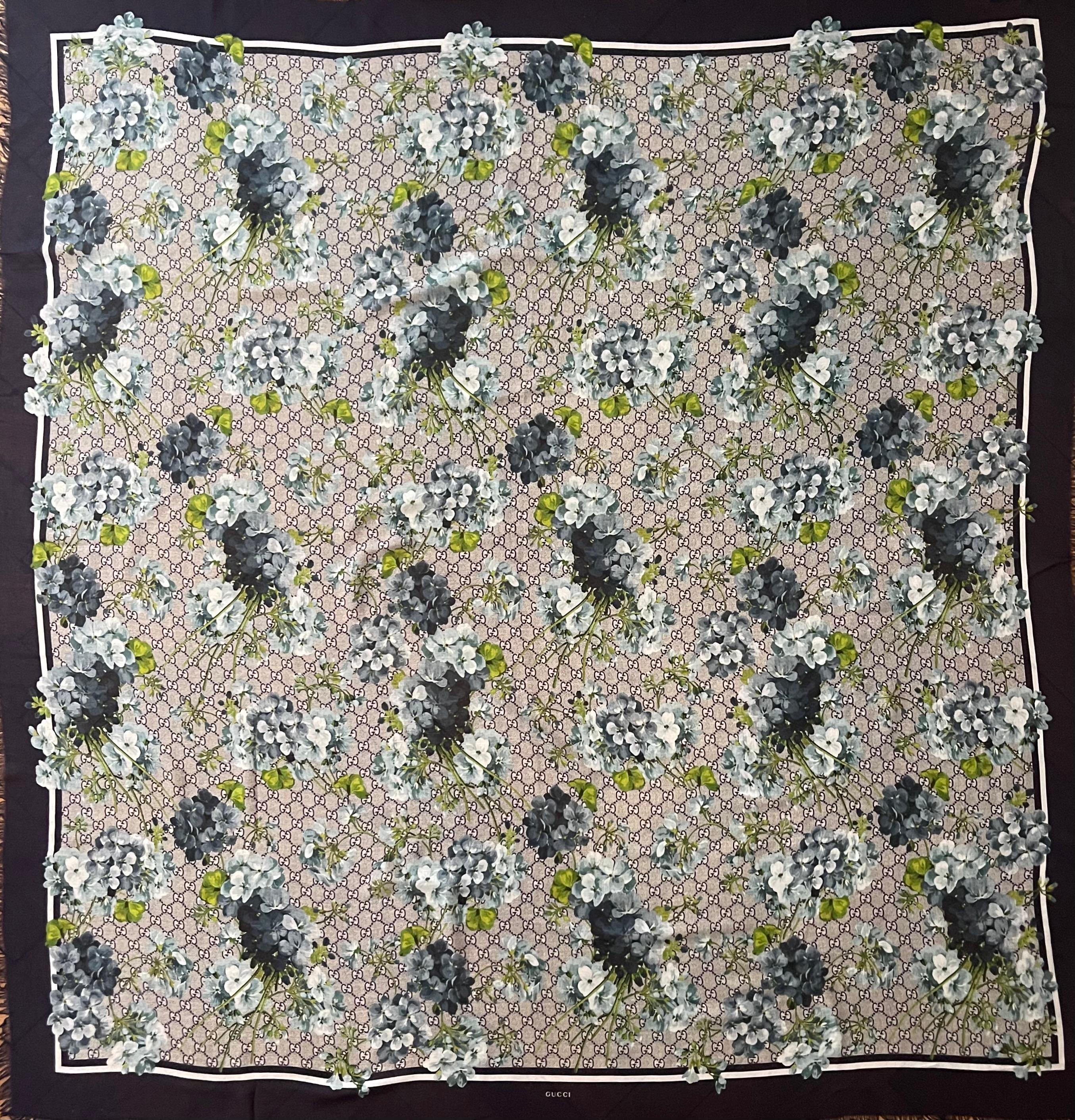 Scialle in seta con Monogram e fiori di Gucci. La sciarpa perfetta è perfetta per elevare ogni tuo outfit. I colori sono bellissimi e il design è unico, può essere considerato un oggetto da collezione ed è molto ricercato dai collezionisti e dagli