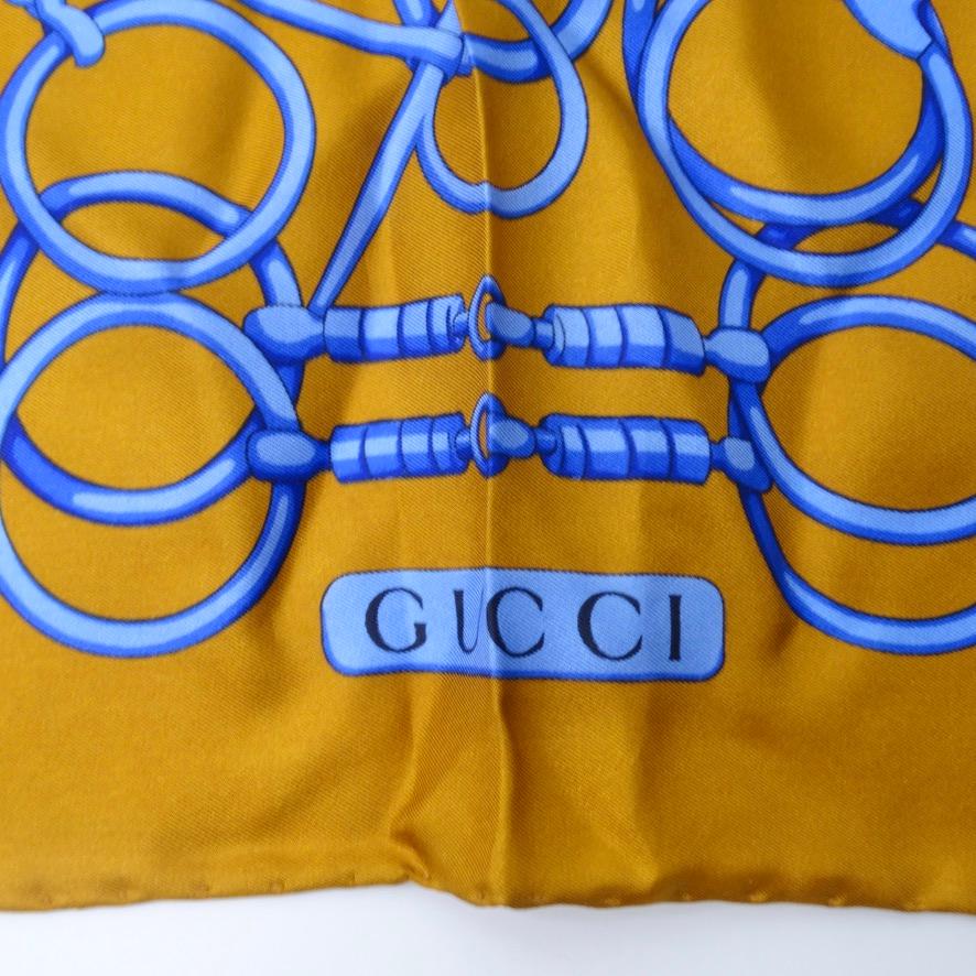 Ce foulard de Gucci datant des années 1980 est incroyable ! Une soie dorée à 100 % contraste avec des nuances de bleu vibrantes qui se rejoignent pour former le motif de mors de cheval caractéristique de Gucci. Remarquez à quel point ce graphisme