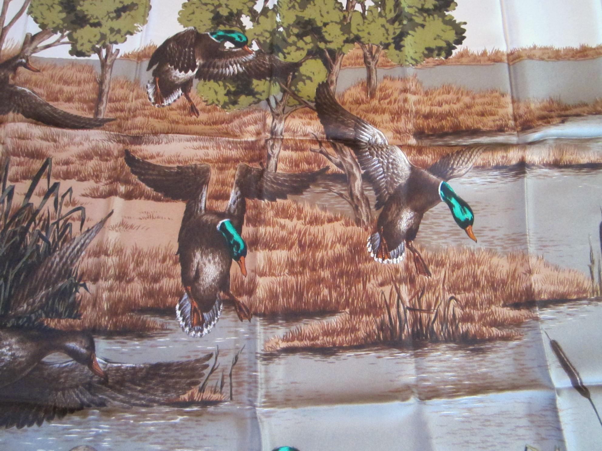 Stunning Browns and greens in this New, never worn Gucci scarf from the 1990s. Duck and Lake scene. 100% Silk. Still folded up the way they came from the store.  Please be sure to check our storefront for more Hermes, Gucci, and Escada scarves of