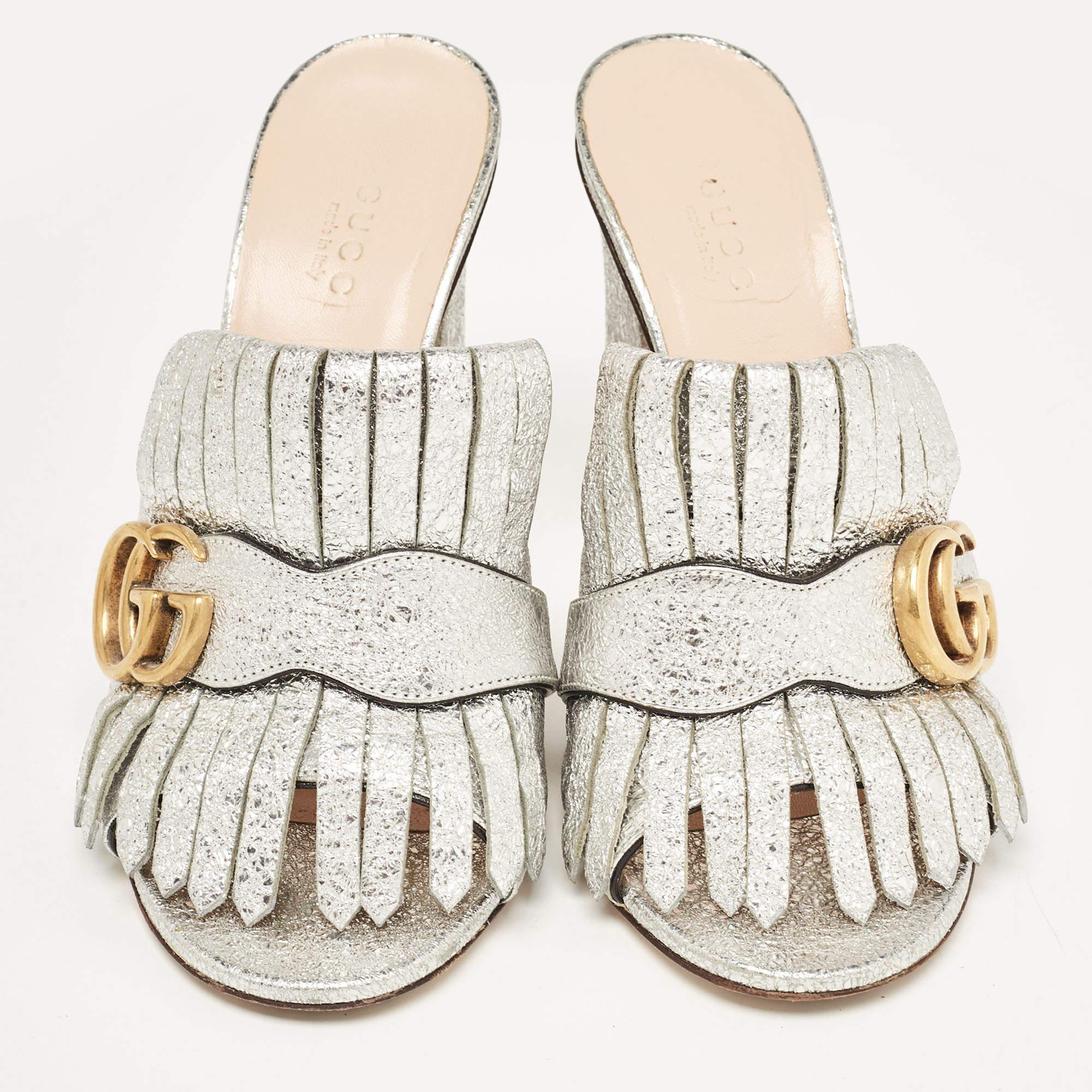 Gucci presents us with an impeccable creation that will make your style stand out. These GG Marmont sandals from Gucci are crafted using silver crackle leather with fringed detailing and a gold-toned GG motif attached to the vamps. They are
