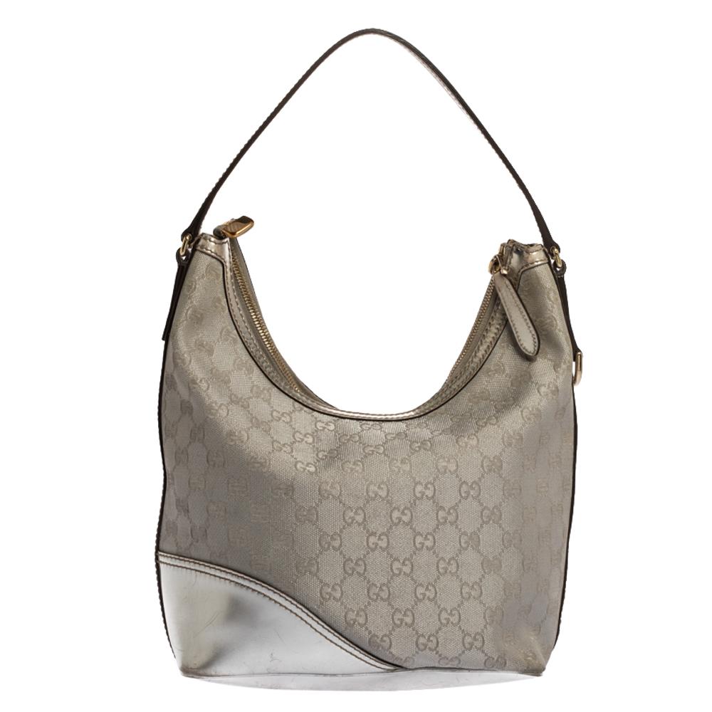 Keep your day look refined yet casual with this New Britt hobo by Gucci. Made from silver GG canvas and leather, it is accented with a GG logo on the corner and a single top handle. The spacious interior is lined with striped fabric with a patch