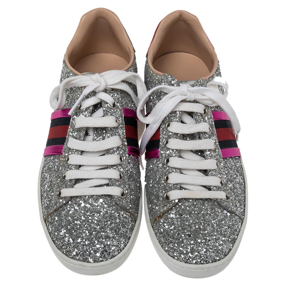 These Ace low-top sneakers are designed to let your feet experience unmatched comfort with never-ending style and luxury. Made by the House of Gucci, these sneakers feature silver glitter and leather on the exterior with the iconic Web strap