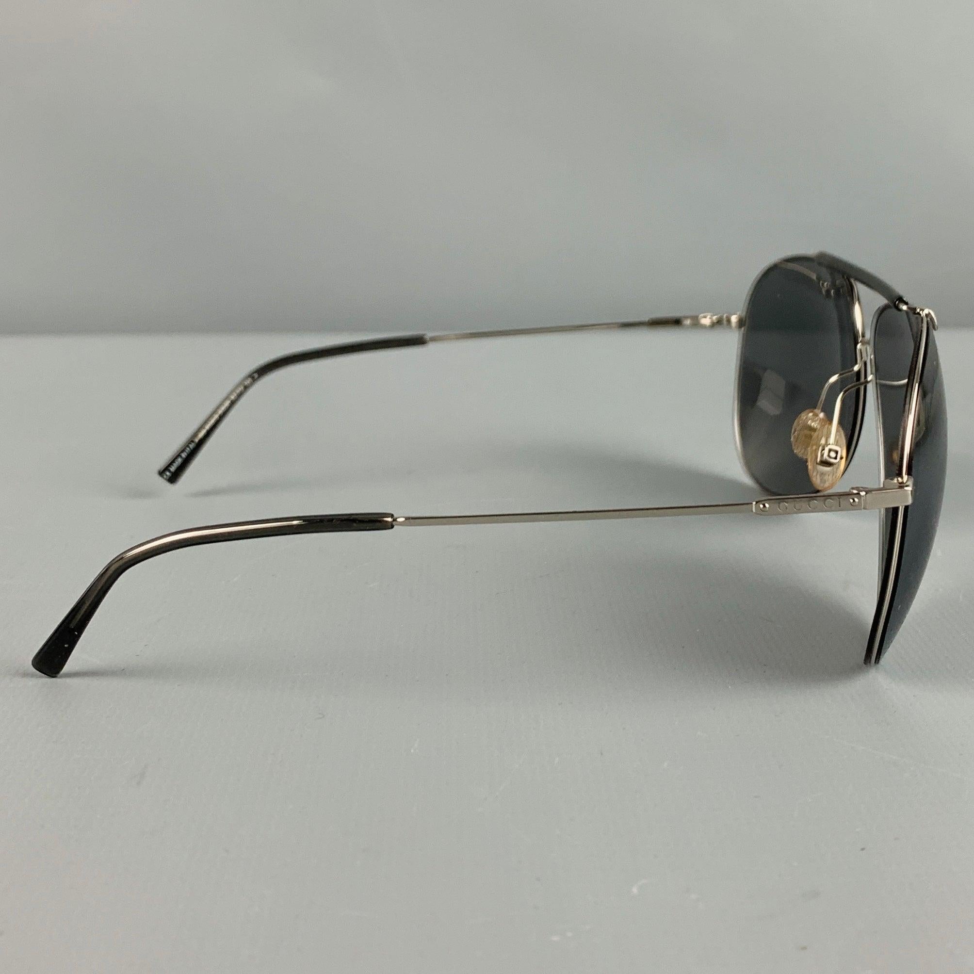 GUCCI sunglasses in a silver tone metal featuring an aviator style, and tinted lenses. Comes with case. Made in Italy.Very Good Pre-Owned Condition. Moderate signs of wear on case, inside and out. As is. 

Marked:   GG 1852/S 0103R 62 12 135