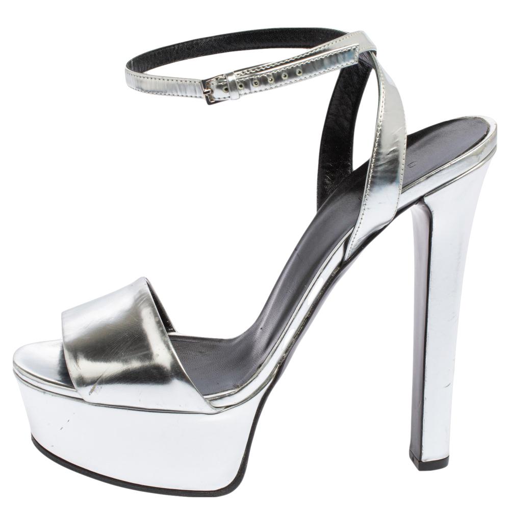 Positively look sharp and radiant as you wear these ankle strap sandals from Gucci. Silver patent leather and silver-toned implements are utilized to make the exterior. A wide strap runs across the upper and has an ankle strap. Lend a stylish and