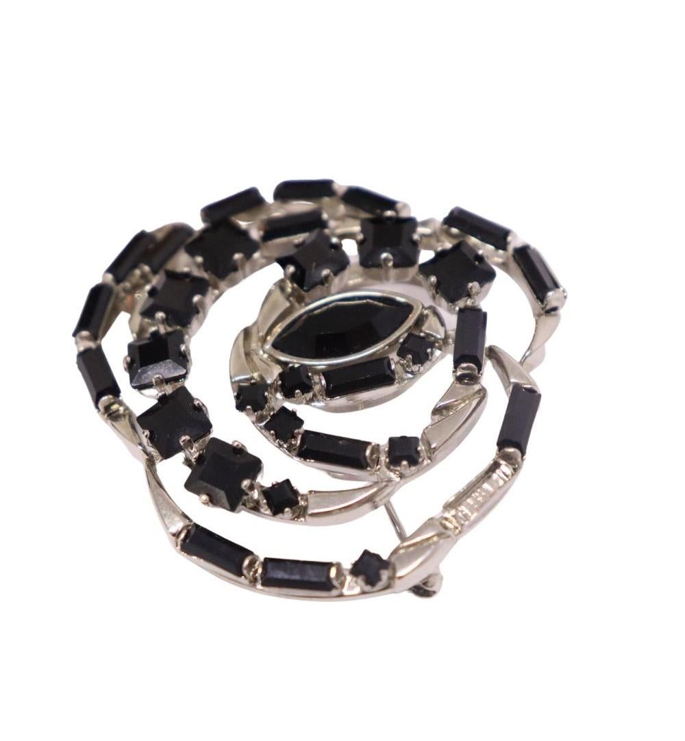 Gucci Silver Rose-shaped Brooch Studded with Black Gemstones.

Material: Silver 
Overall condition: Very good
Missing one of the black gemstones