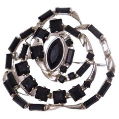 Silberbrosche von Gucci in Rosenform, mit schwarzen Edelsteinen besetzt