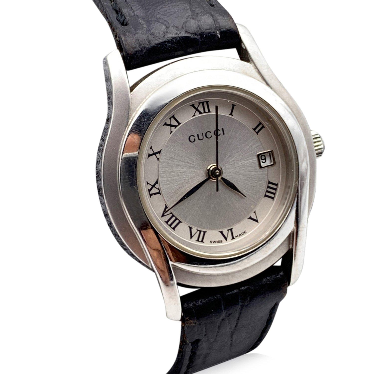 Gucci silver tone stainless steel wrist watch, mod. 5500 L. White Dial. Date at 3 o'clock. Sapphire crystal. Swiss Made Quartz movement. Gucci written on face. Roman numbers. Gucci crest on the reverse of the case. Water Resistant to 3 atm. Black