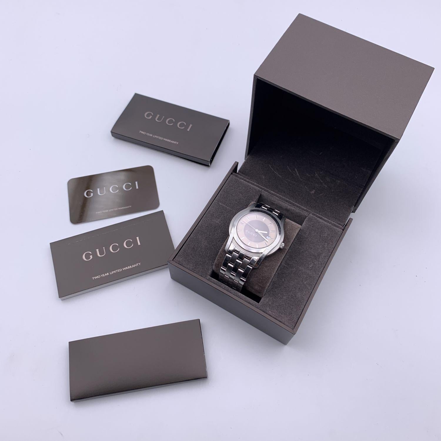 Gucci silver tone stainless steel wrist watch, mod. 5500 XL. Beige and brown bicolor dial. Date at 3 o'clock. Sapphire crystal. Swiss Made Quartz movement. Gucci written on face. Gucci crest on the reverse of the case. GUCCI logo engraved on the