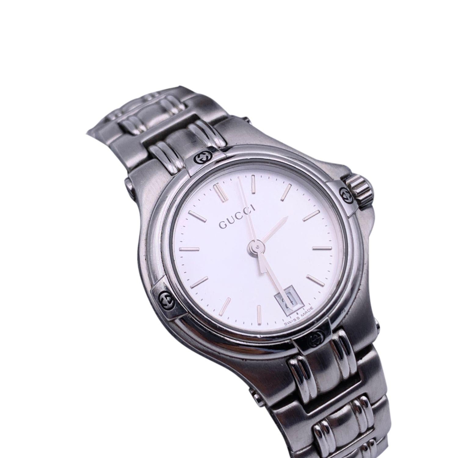 Gucci stainless steel wrist watch, mod. 9040 L. Stainless steel case. Silver Dial. Date at 6 o'clock. Sapphire crystal. Swiss Made. Quartz movement. Gucci written on face. Gucci crest on the reverse of the case. GG logo engraved on the clasp. Water