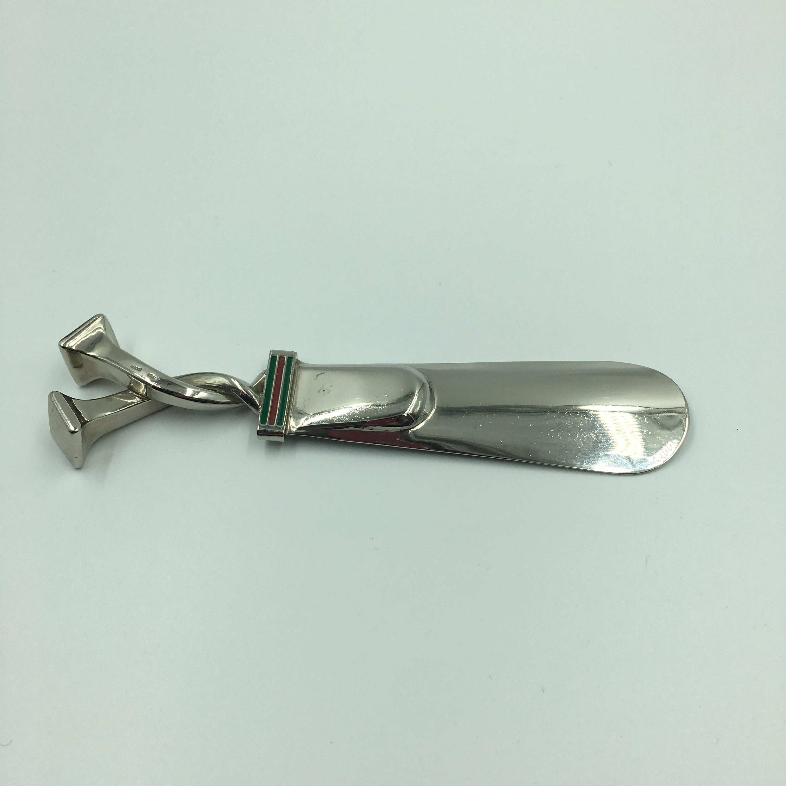 Gucci Shoehorn Silver Tone Metal with Red and Green Classic Enamel Stripe. Front and back feature the classic Gucci red and green stripe, in enamel paint, at bottom of twisted nail head motif handle. Stamped Gucci and Italy on back of twisted