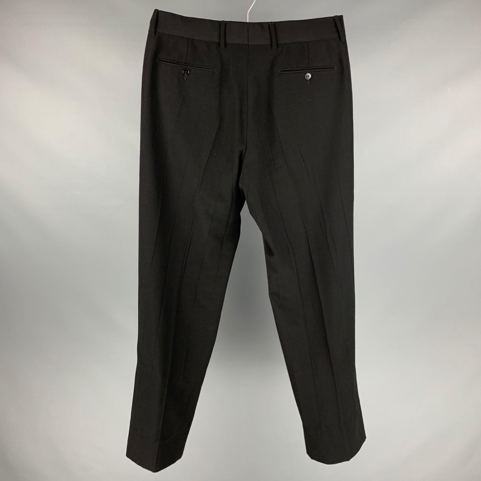GUCCI dress pants in a black wool featuring a flat front style, exposed hem, and a zipper fly closure. Made in Switzerland.Very Good Pre-Owned Condition. Minor signs of wear. 

Marked:  7-50R 

Measurements: 
 Waist: 34 inches Rise: 11.5 inches