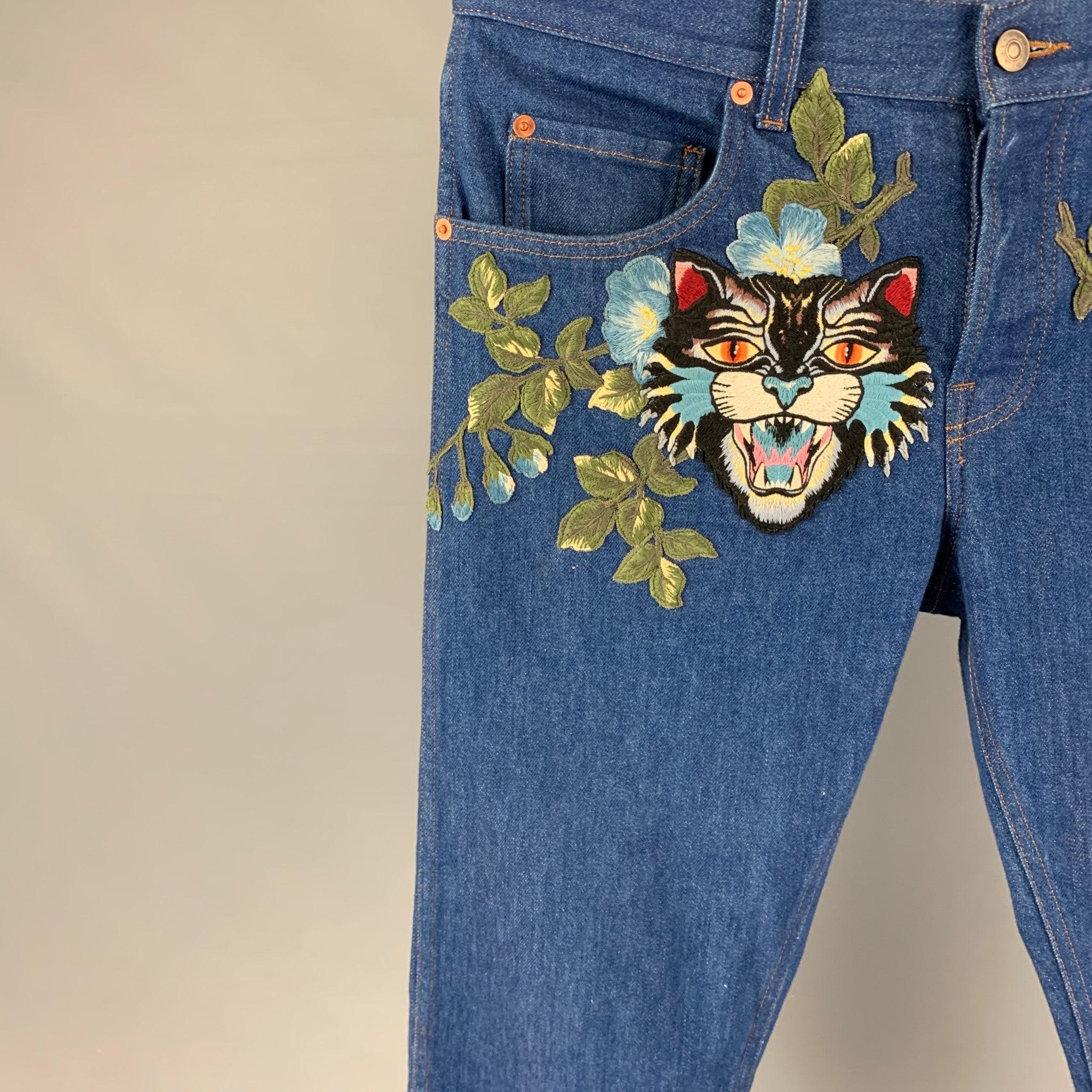 GUCCI jeans comes in a blue denim featuring a tapered leg, angry cat patch design, contrast stitching, and a button fly closure. Made in Italy.
Very Good
Pre-Owned Condition. 

Marked:   34 

Measurements: 
  Waist: 34 inches  Rise: 11 inches 