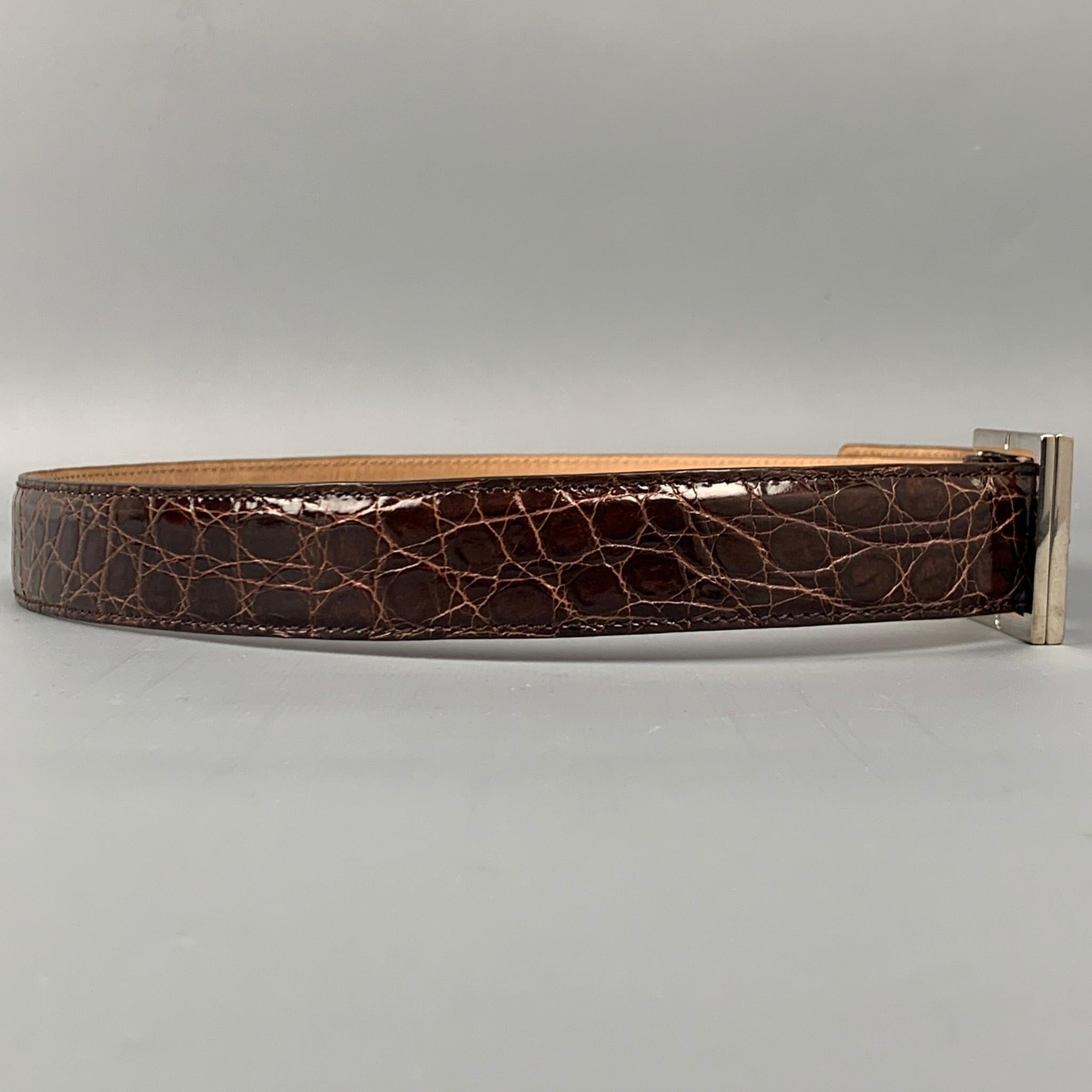 GUCCI belt comes in a brown alligator leather featuring a silver tone buckle closure. Made in Italy.

Very Good Pre-Owned Condition.
Marked: 223901-1766-85-34

Length: 40 in.
Width: 1.25 in.
Fits: 32 in. - 36 in.
Buckle: 1.5 in. 