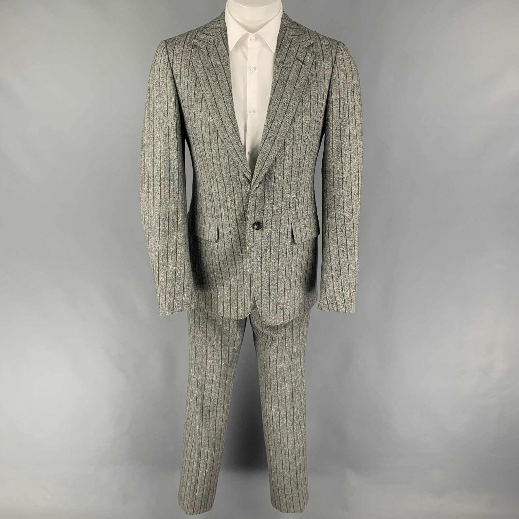 GUCCI
suit comes in
 a grey stripe wool blend with a full liner and includes a breasted, double button sport coat with a notch lapel and matching flat front trousers. Made in Italy. Very Good Pre-Owned Condition. 

Marked:   48 R  

Measurements: 
 