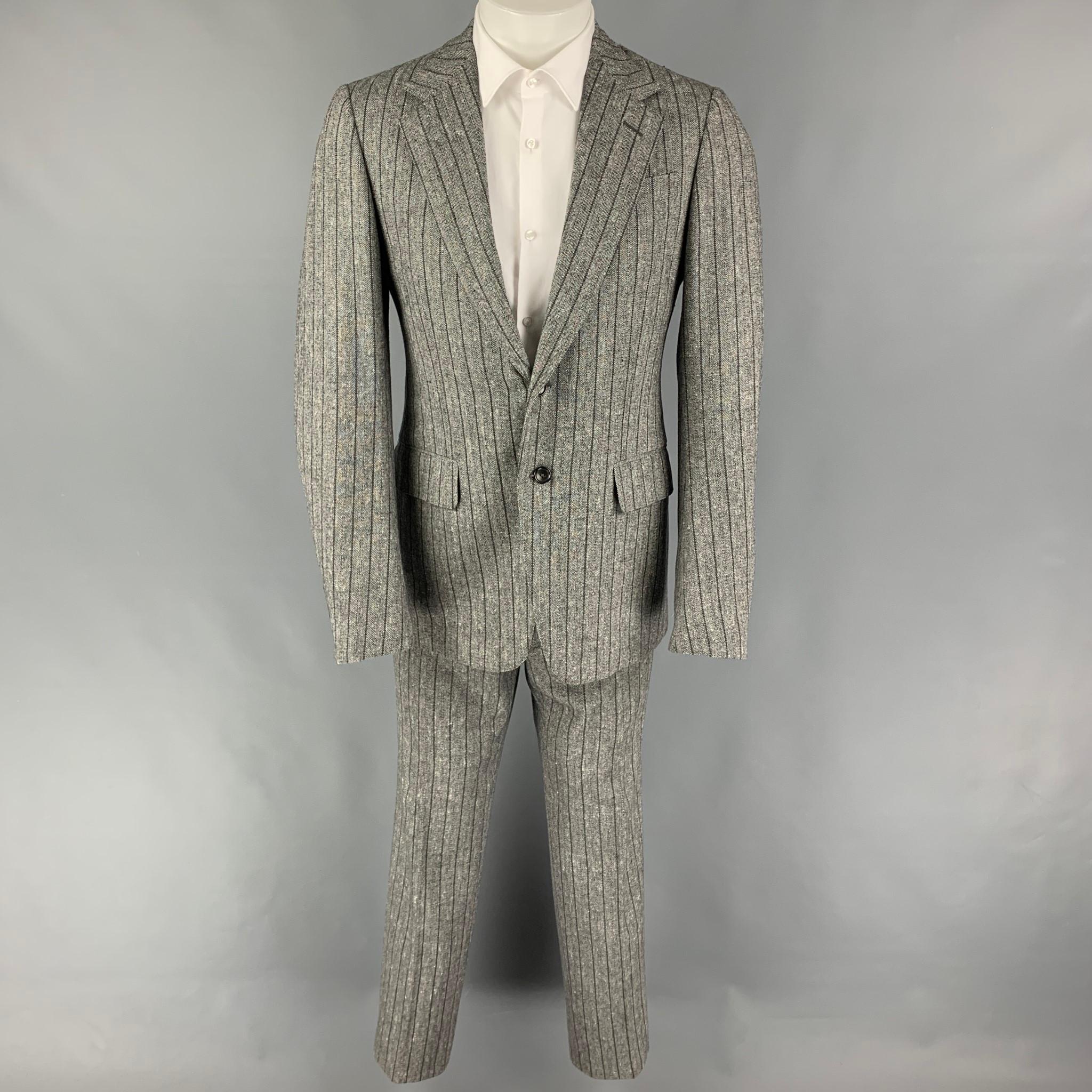 GUCCI suit comes in  a grey stripe wool blend with a full liner and includes a breasted, double button sport coat with a notch lapel and matching flat front trousers. Made in Italy.

Very Good Pre-Owned Condition.
Marked: 48