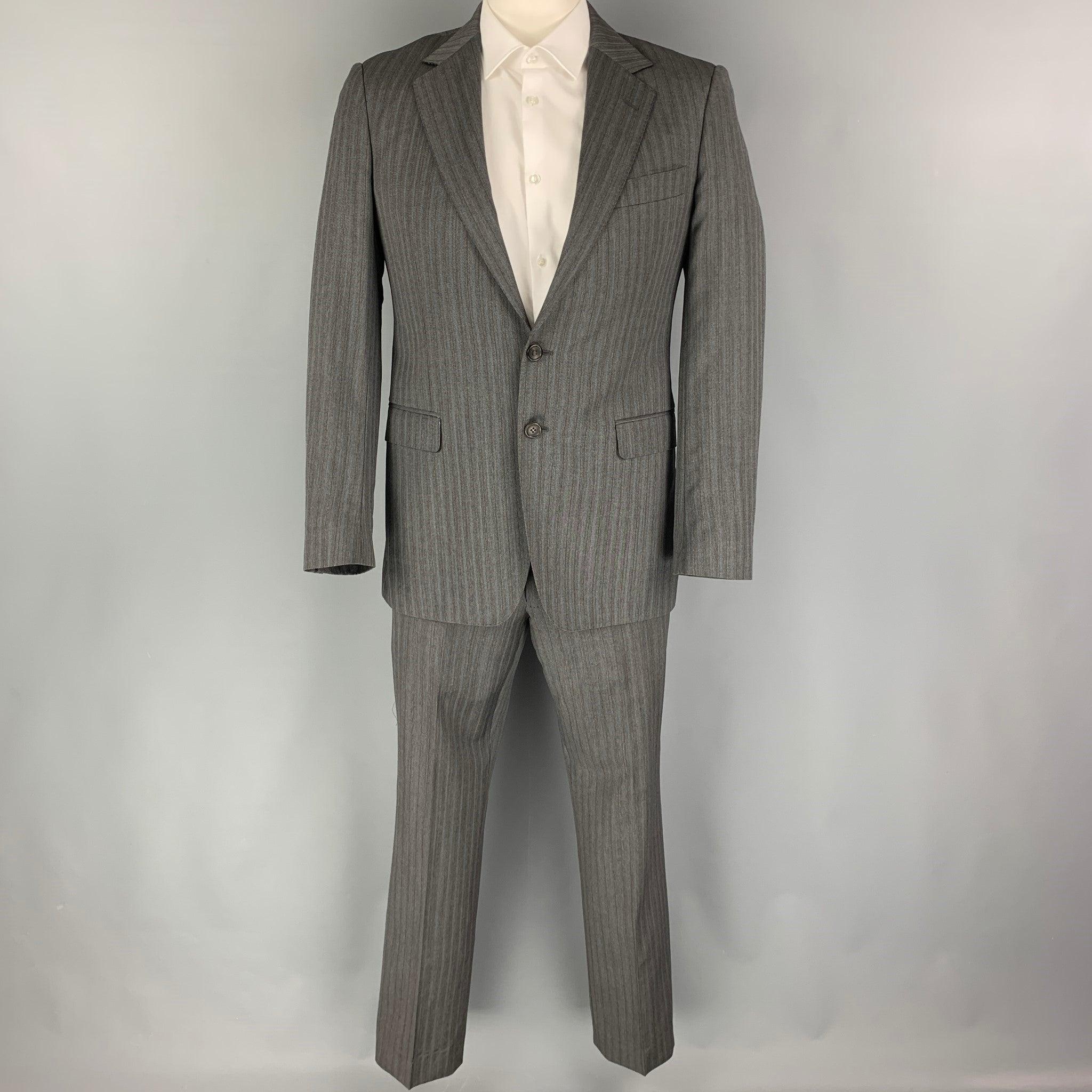 GUCCI
suit comes in a grey & blue stripe wool with a full liner and includes a single breasted, double button sport coat with a notch lapel and matching flat front trousers. Good Pre-Owned Condition. Moderate wear at pants interior. As-is. 