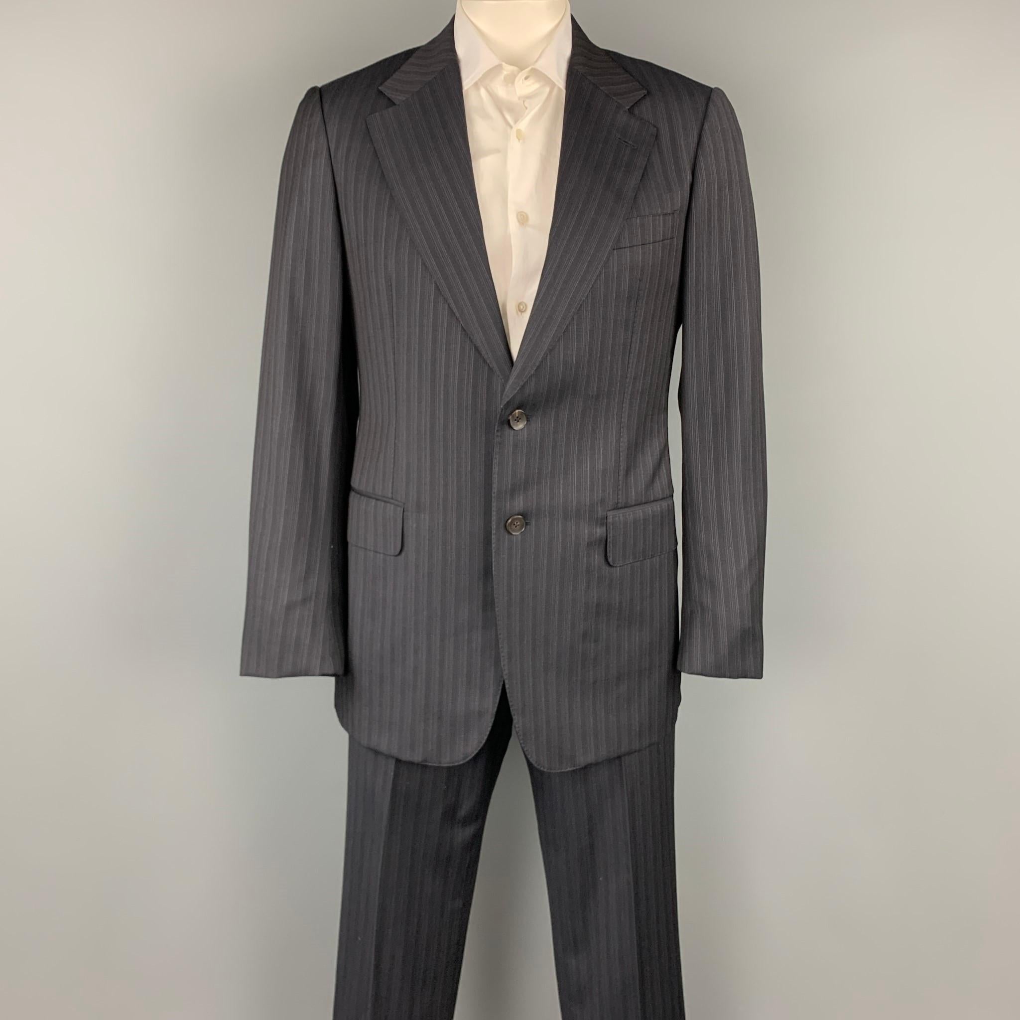GUCCI suit comes in a black stripe wool with a full liner and includes a single breasted, two button sport coat with a notch lapel and matching flat front trousers. Made in Italy.

Very Good Pre-Owned Condition.
Marked: IT 52