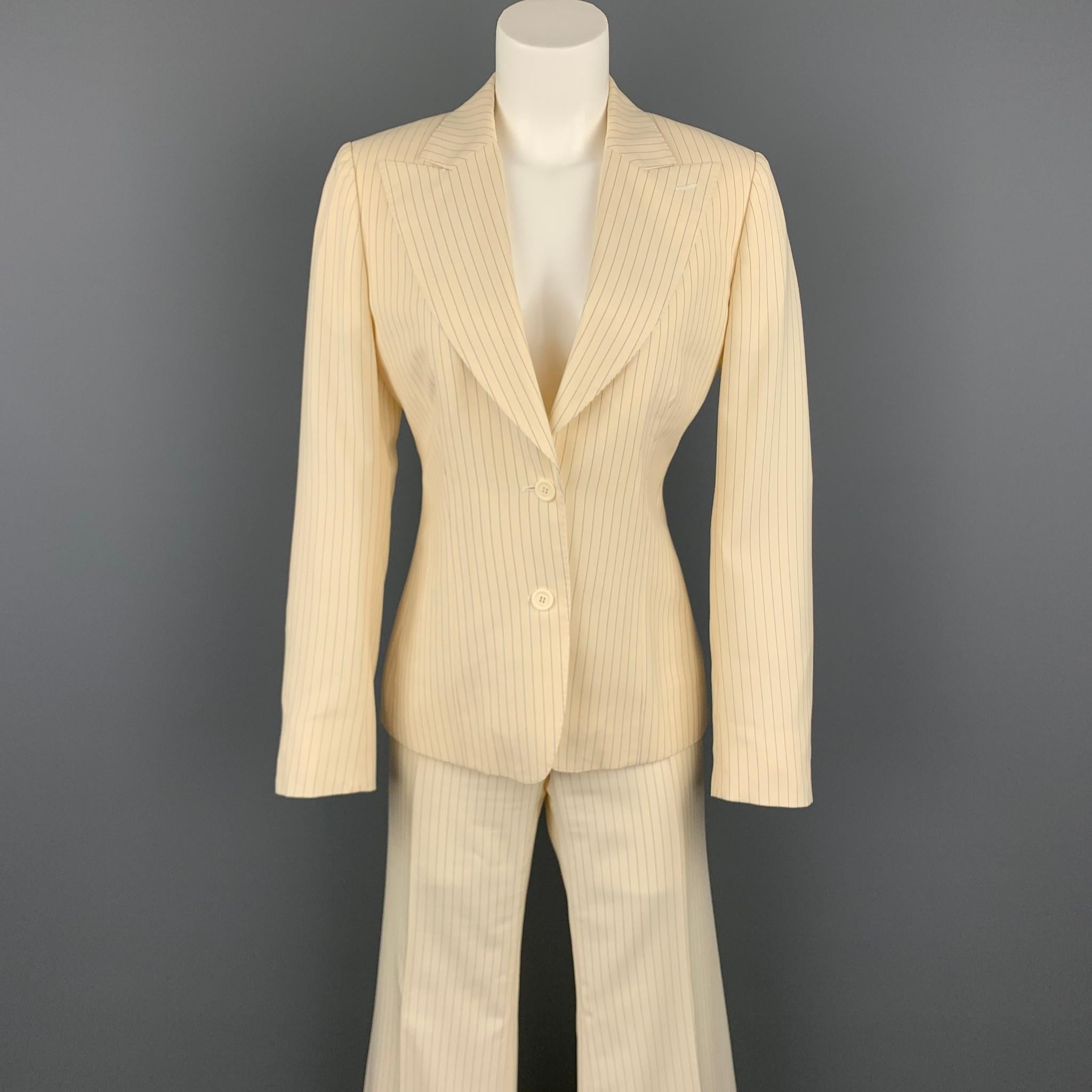 GUCCI suit comes in a cream & navy pinstripe wool with a full liner and includes a single breasted, two button sport coat with a peak lapel and matching  wide leg front trousers. Made in Italy.

Very Good Pre-Owned Condition.
Marked: IT
