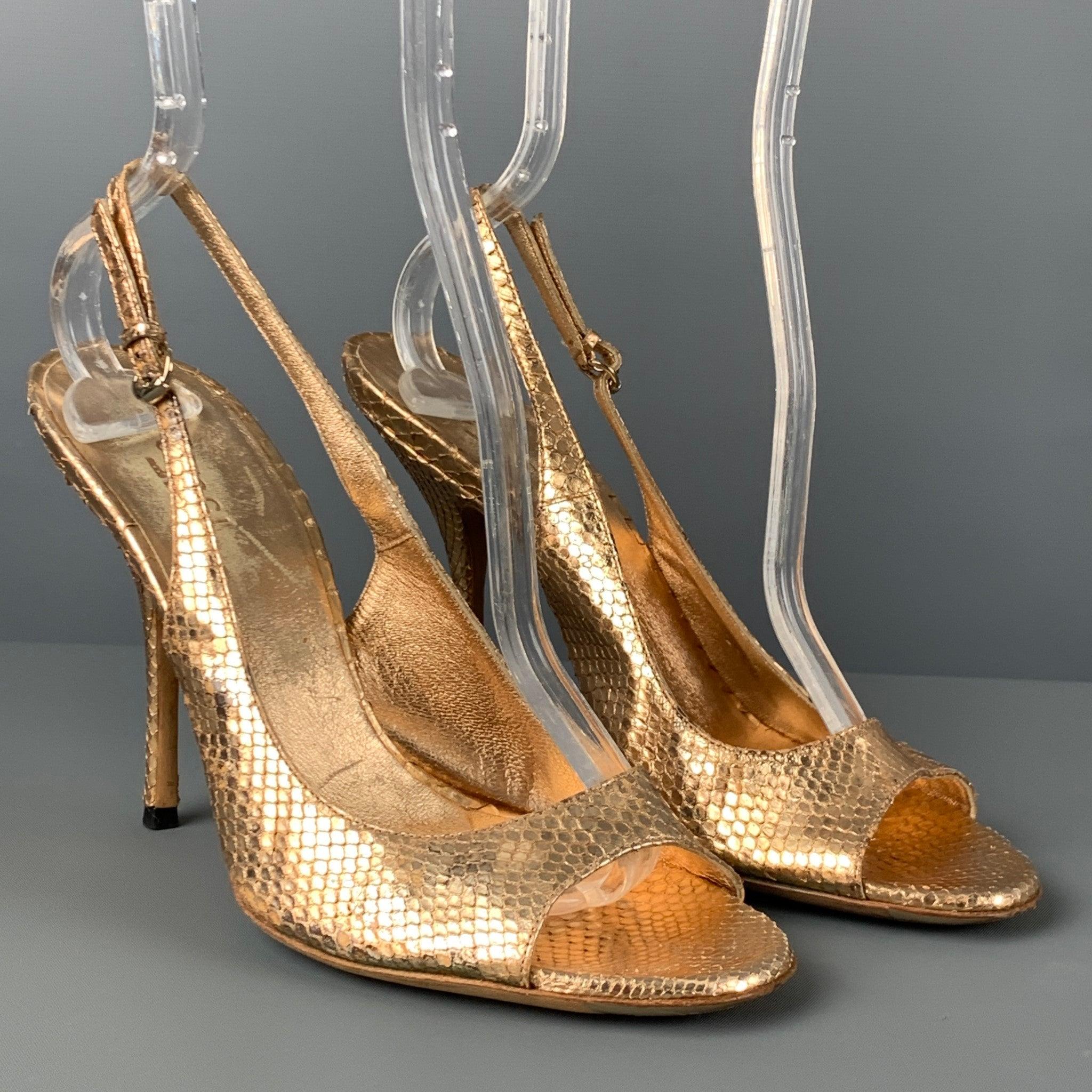 GUCCI sandals comes in a gold metallic snakeskin leather featuring a adjustable sling back design, open toe, and a stiletto heel. Made in Italy.Good
Pre-Owned Condition.
Light wear throughout. As-is.  

Marked:   37 C 

Measurements: 
  Heel: 4.25