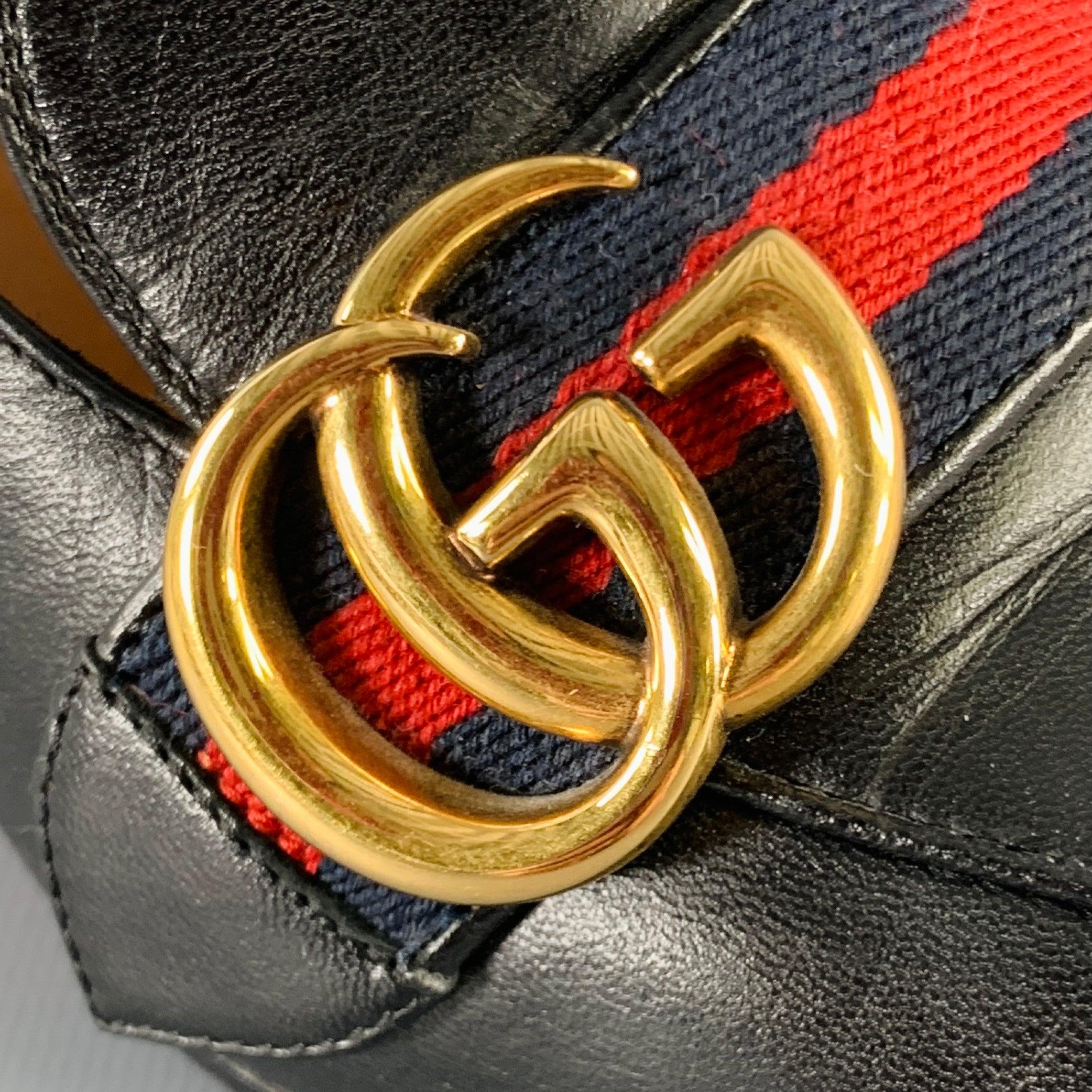 GUCCI Marmont pumps
in a black leather fabric featuring a loafer style, signature red stripes with Double G gold tone buckles, and gold tone studded heel details with pearl accents. Made in Italy.Excellent Pre-Owned Condition. 

Marked:   425943