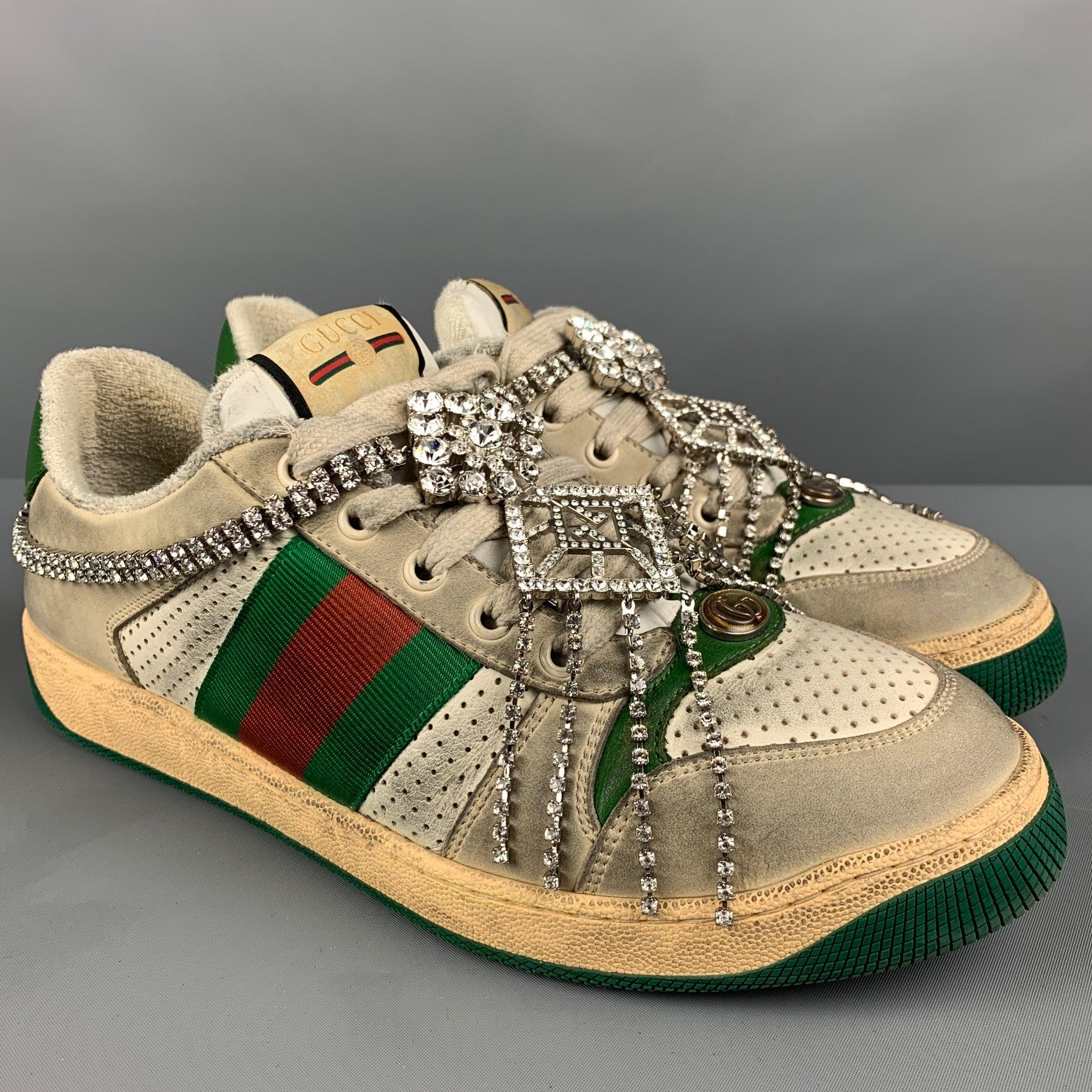 GUCCI 'Screener' sneakers in an off white distressed leather featuring a removable Art Deco GG crystal chain, web stripe detail, perforated, rubber sole, and a lace up closure. Comes with box. Made in Italy. Very Good Pre-Owned Condition.  

Marked: