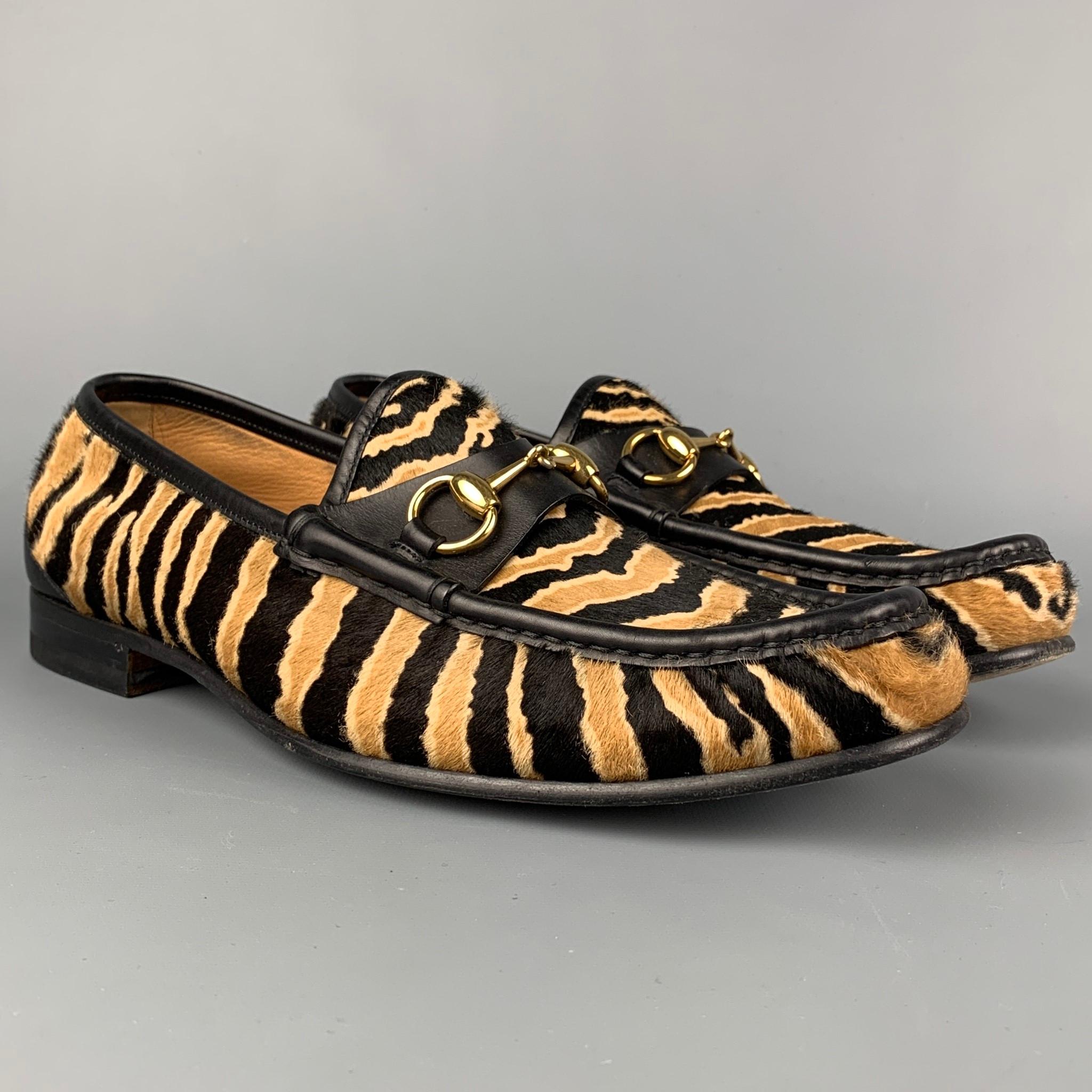 GUCCI loafers comes in a black & beige calf hair featuring a gold tone horsebit design, leather trim, and a slip on style. Made in Italy. 

Very Good Pre-Owned Condition.
Marked: 297964 8.5
Original Retail Price: $1,080.00

Outsole: 11.5 in. x 4 in. 