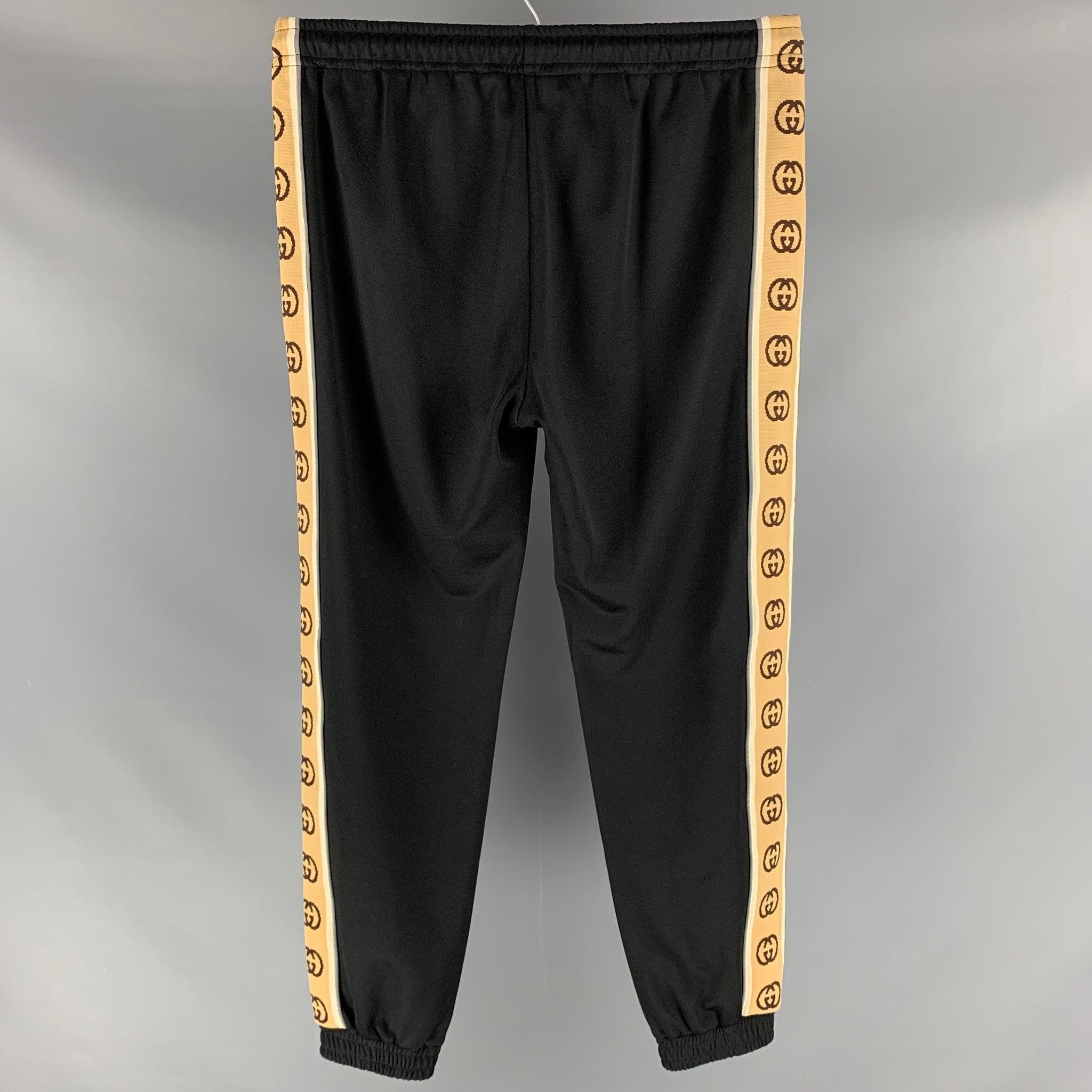 GUCCI sweatpants comes in a polyester and cotton knit jersey fabric featuring a khaki monogram trim detail, zip up pockets, elastic waist and a drawstring detail. Made in Italy. Excellent Pre- Owned Condition. 

Marked:   L 

Measurements: 
  Waist: