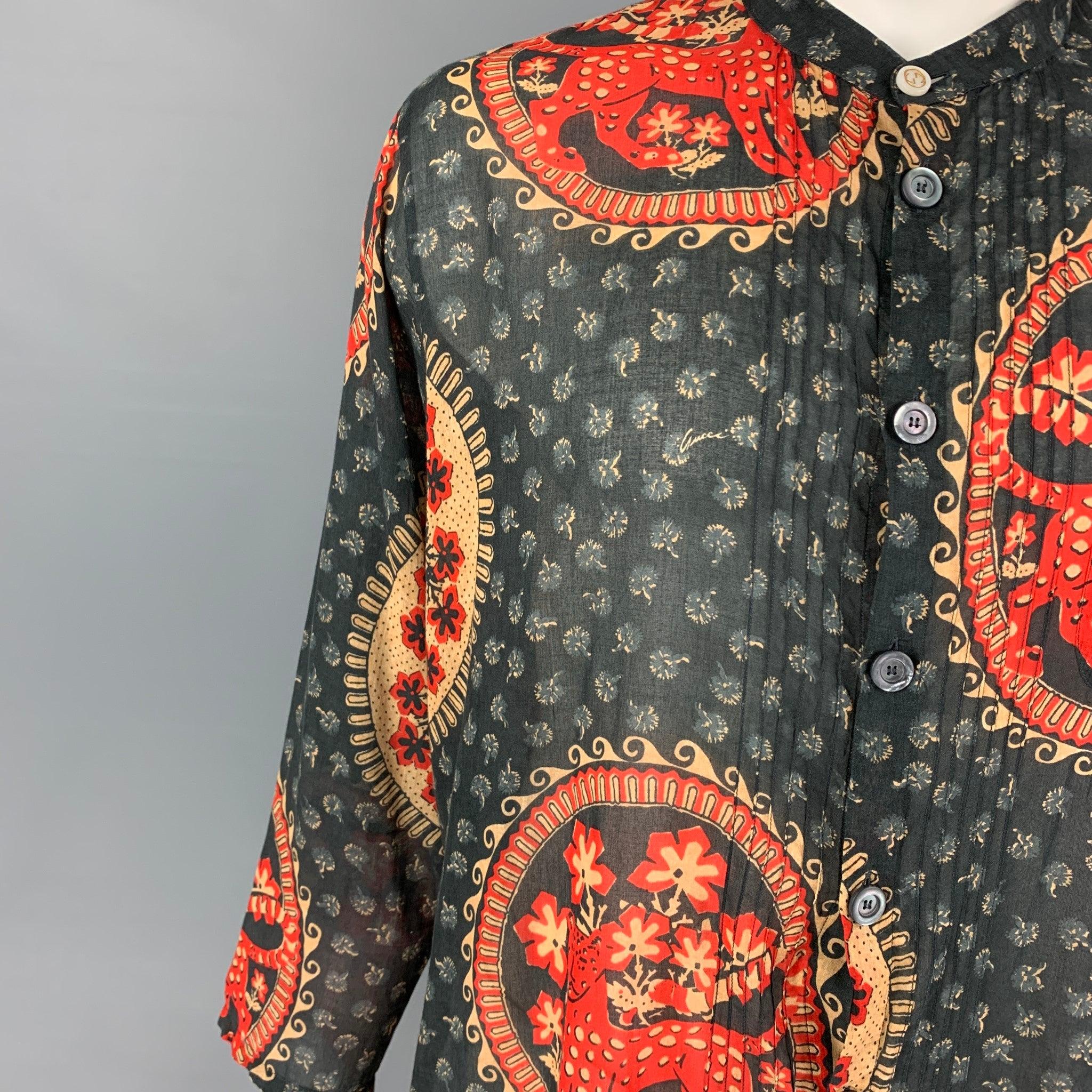 Das langärmelige Hemd von GUCCI aus grauer Baumwolle mit rotem und khakifarbenem Aufdruck hat eine lockere Passform, einen Nehru-Kragen, Plisseefalten, eine Logo-Knopfleiste, eine aufgesetzte Tasche und einen Knopfverschluss. Hergestellt in