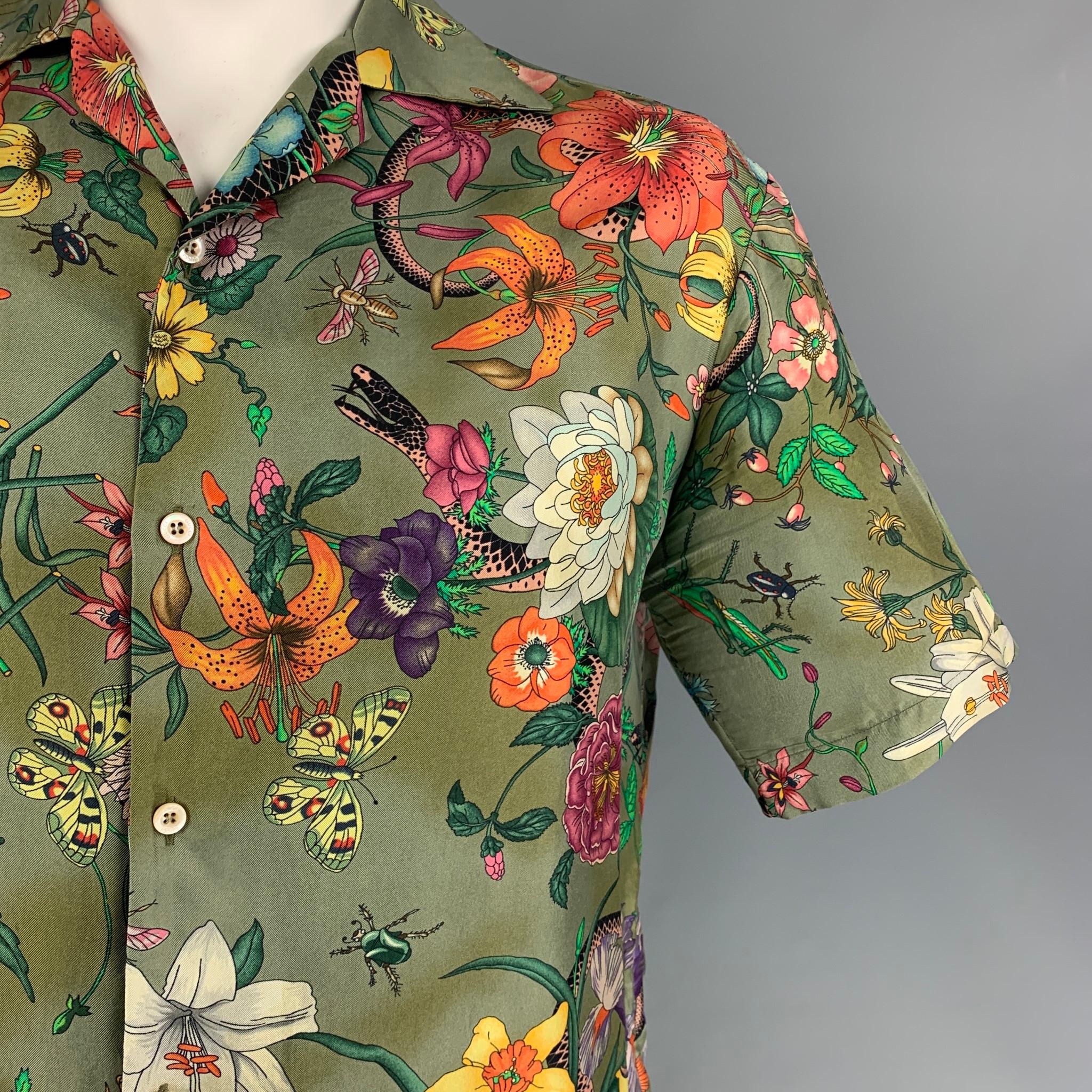 GUCCI short sleeve shirt comes in a multi-color floral print silk featuring a camp collar, loose fit, black trim, and a buttoned closure. Made in Italy. 

Very Good Pre-Owned Condition.
Marked: 52

Measurements:

Shoulder: 21 in.
Chest: 48