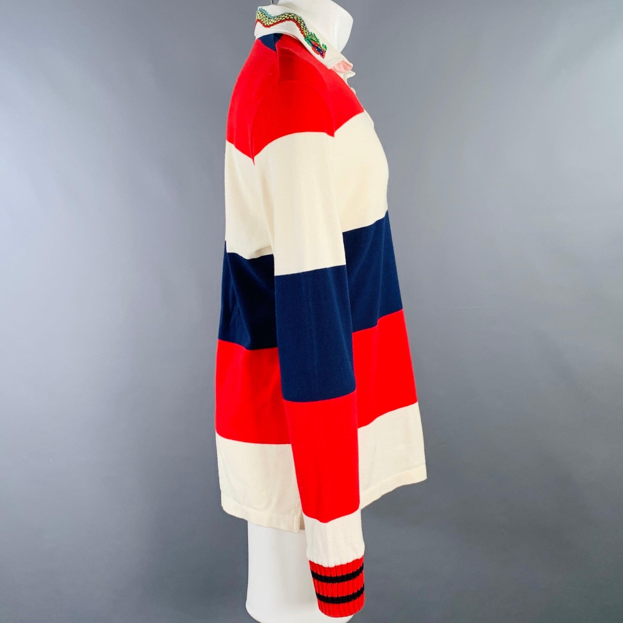 GUCCI-Polo
aus cremefarbenem, marineblauem und rotem Stoff (fühlt sich an wie Baumwollpiqué) mit Streifenmuster, langen Ärmeln und halber Knopfleiste mit roter Drachenapplikation am Kragen.
Made in Italy. sehr guter gebrauchter Zustand. Mehrere