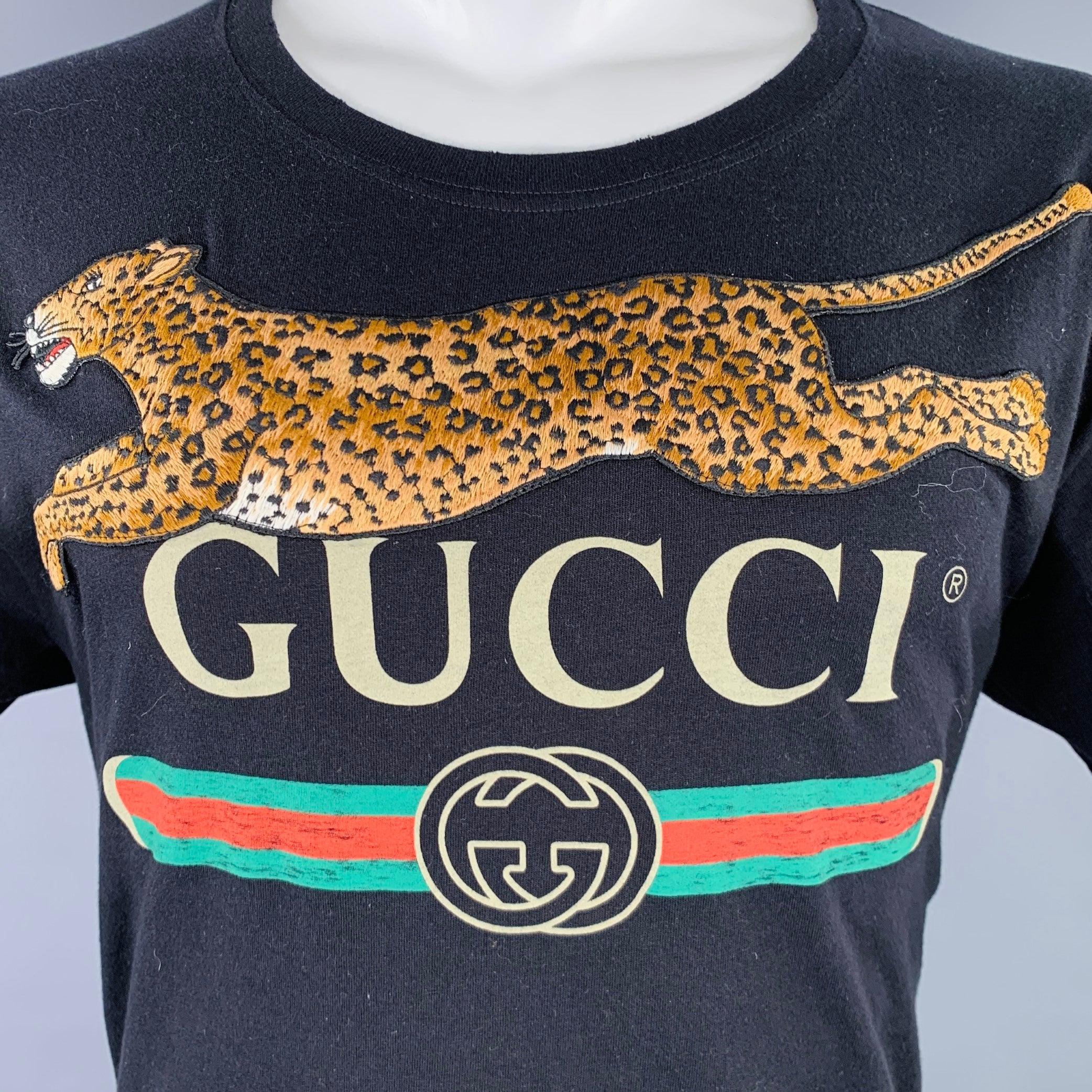 GUCCI t-shirt
in a black jersey fabric featuring GUCCI logo, leopard applique, and crew neck.Very Good Pre-Owned Condition. Minor marks. 

Marked:   S 

Measurements: 
 
Shoulder: 21 inches Chest: 42 inches Sleeve: 8.5 inches Length: 27.5 inches 
 